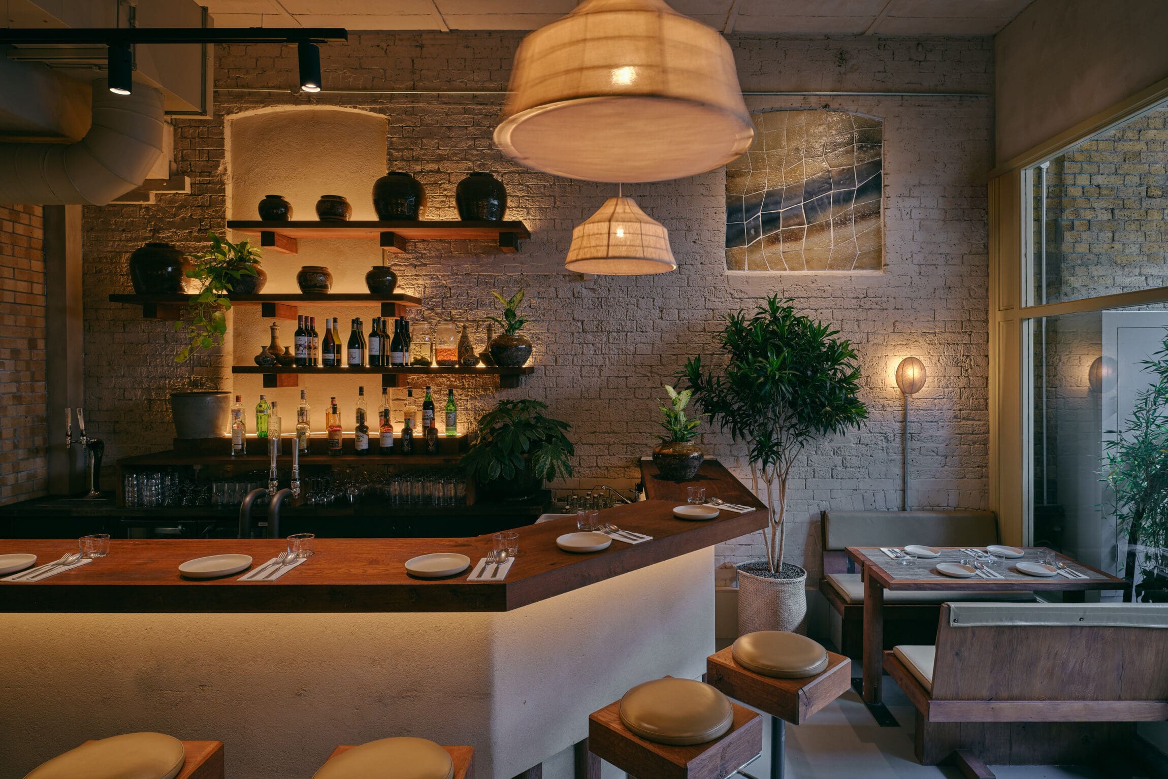 Best London Bridge and Borough Restaurants | a low-lit bar framed by pendant lights and potted plants