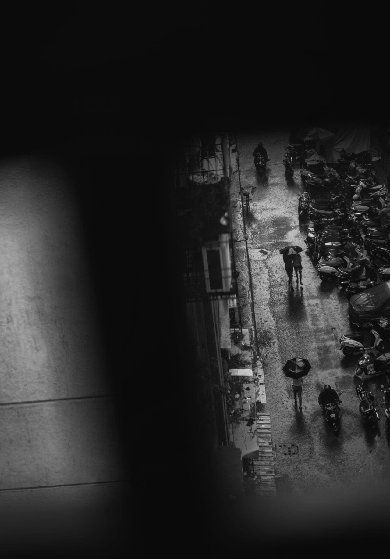 Photographer Sunhil Sippy on Mumbai | Figures walk along an empty street, holding umbrellas