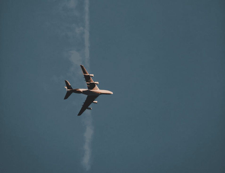 High-altitude view of an airplane soaring through the clear blue sky.