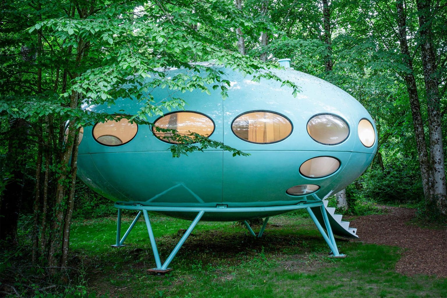Holidays rentals adapting for digital nomads | A UFO-like structure with a rounded shape and oval windows sits in a wooded glade