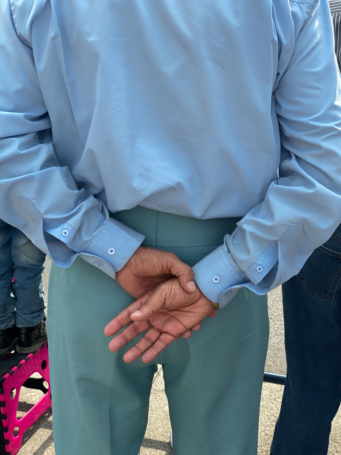 Photographer Manuel Zúñiga on Mexico City | A man wearing a pale-blue shirt and teal trousers clasps his hands behind his back and faces away from the camera