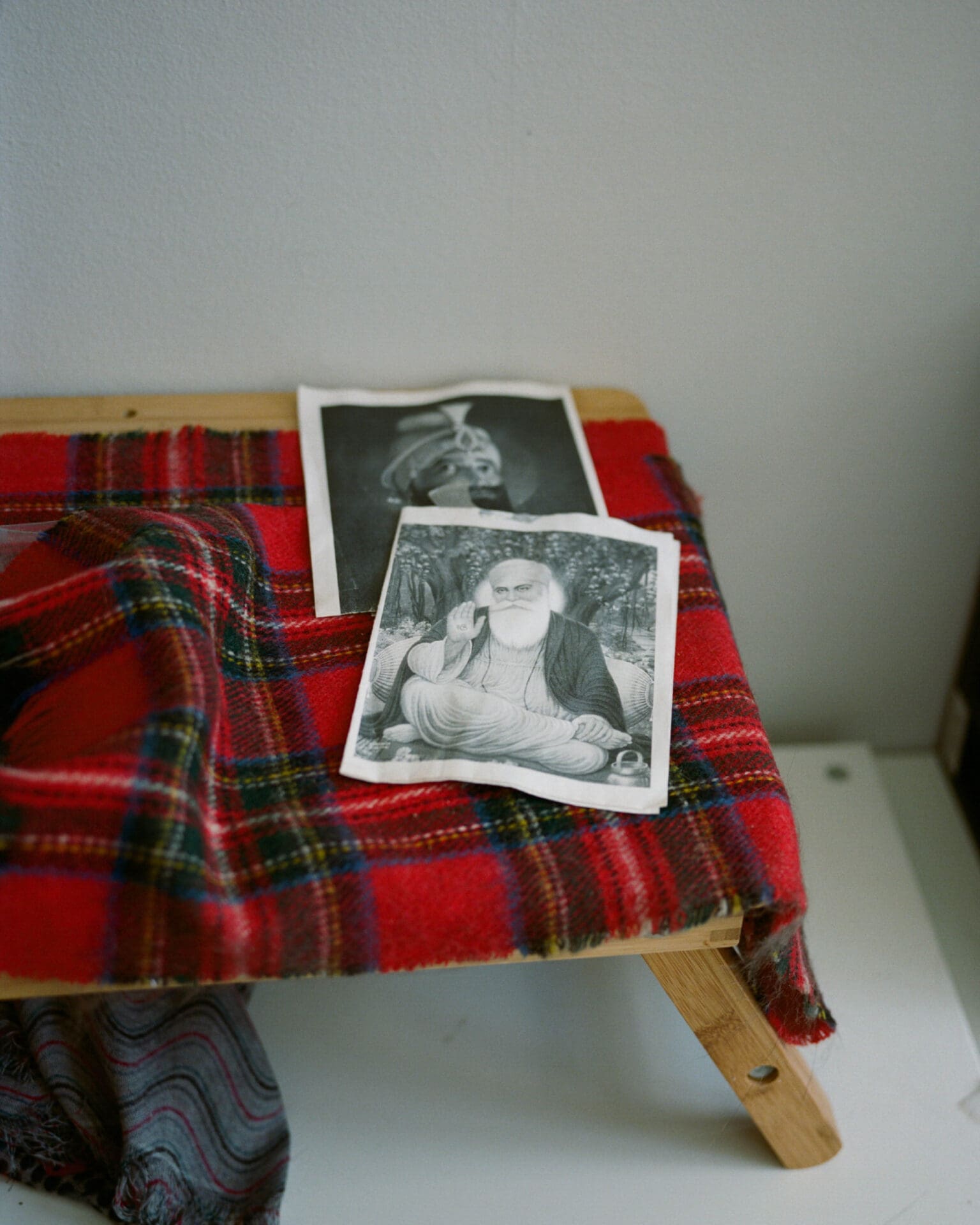 An interview with poet Nikita Gill | Two black and white photos lie on a tartan blanket on a bench