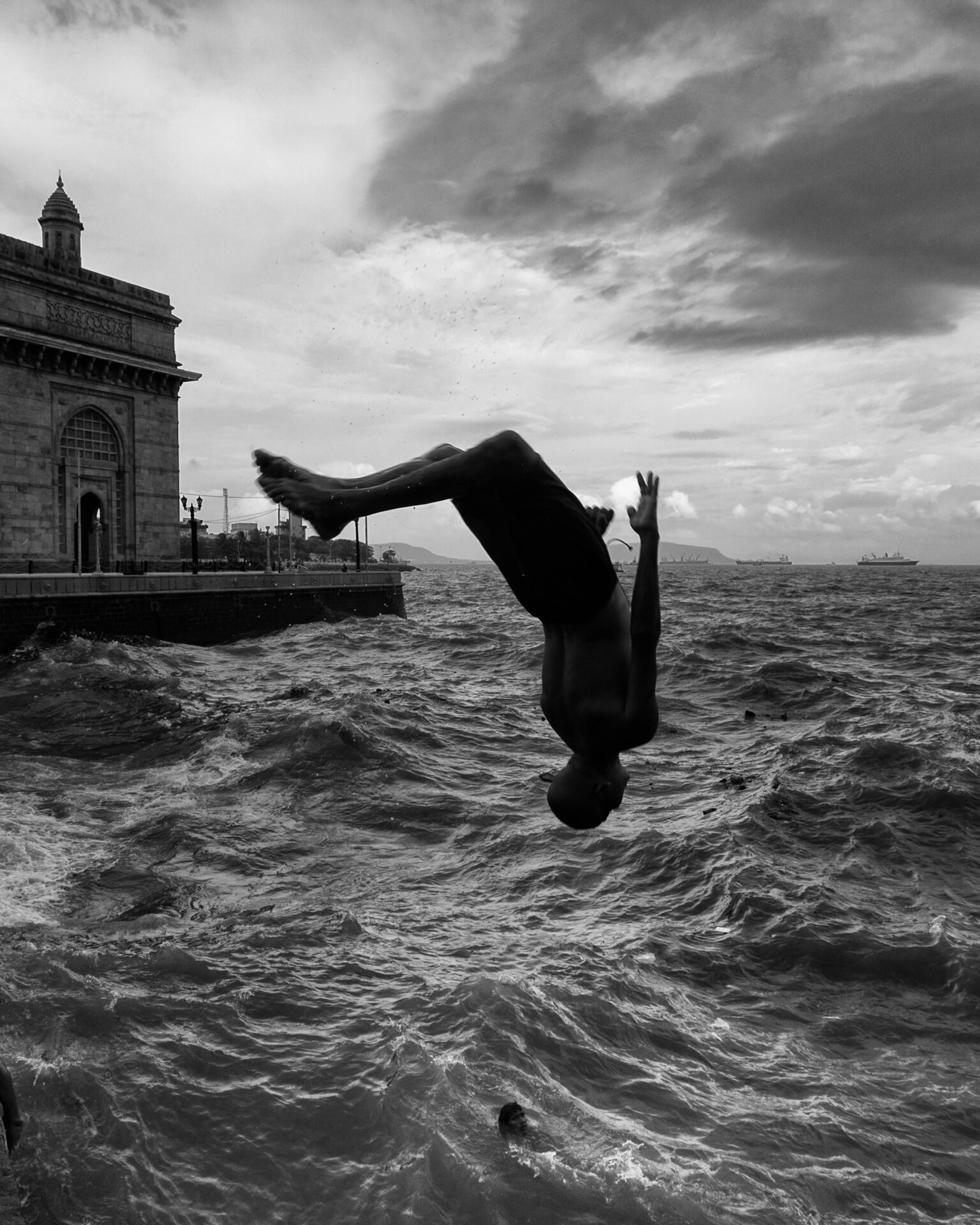 Photographer Sunhil Sippy on Mumbai | the silhouette of a person backflipping into choppy waters