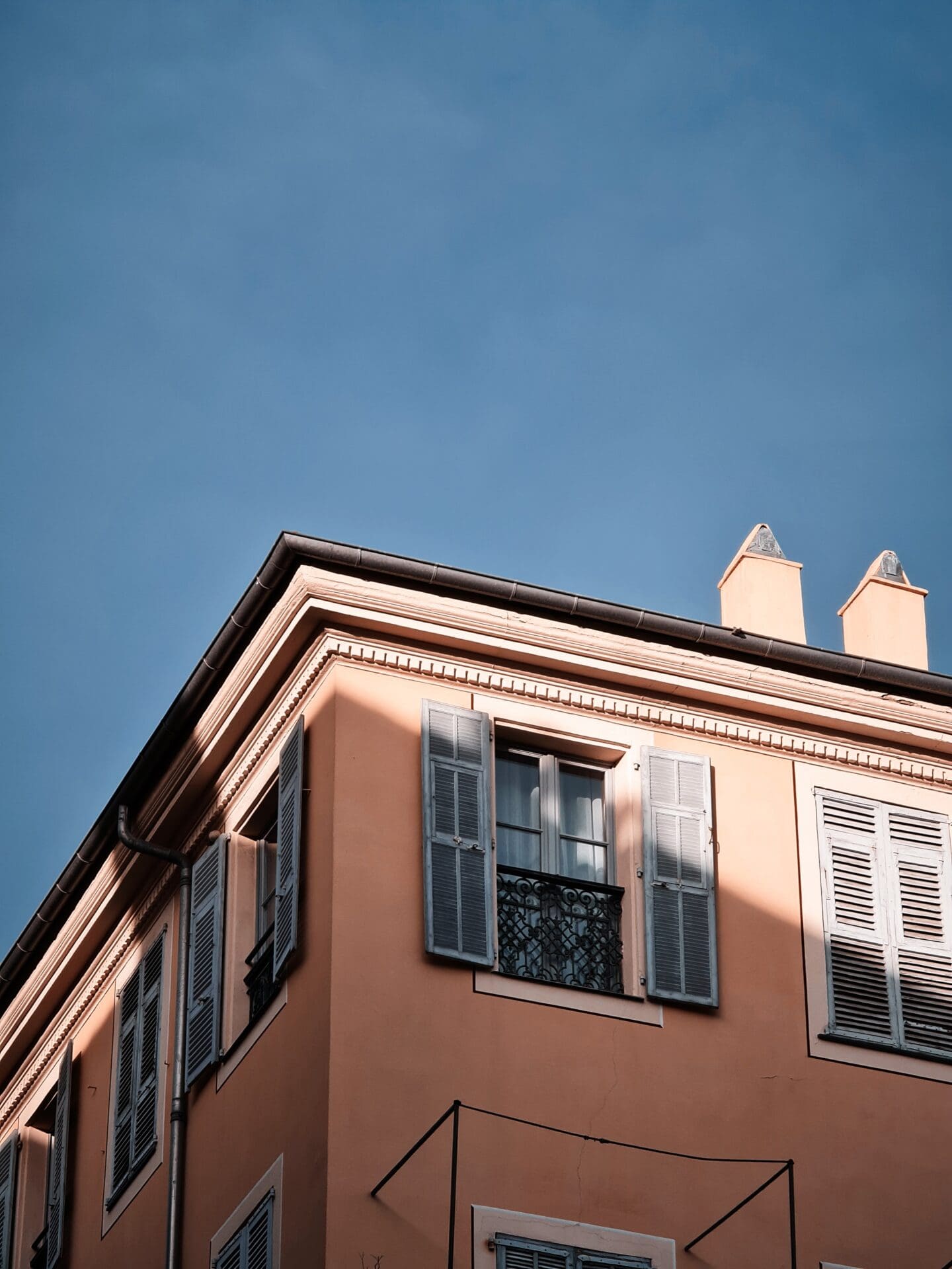 Running in Nice | a peach-toned building beneath a blue sky in Nice on the French Riviera