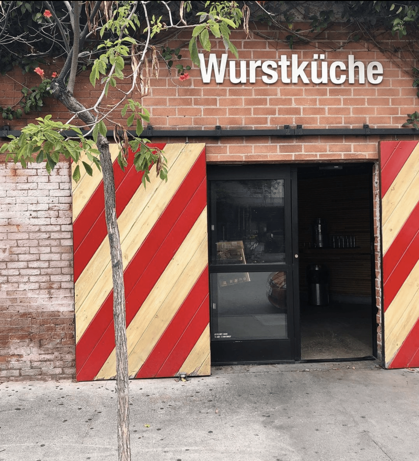 Best restaurants LA Arts District | The front door at beer hall Wurstküche, with red and yellow striped wooden sliding doors