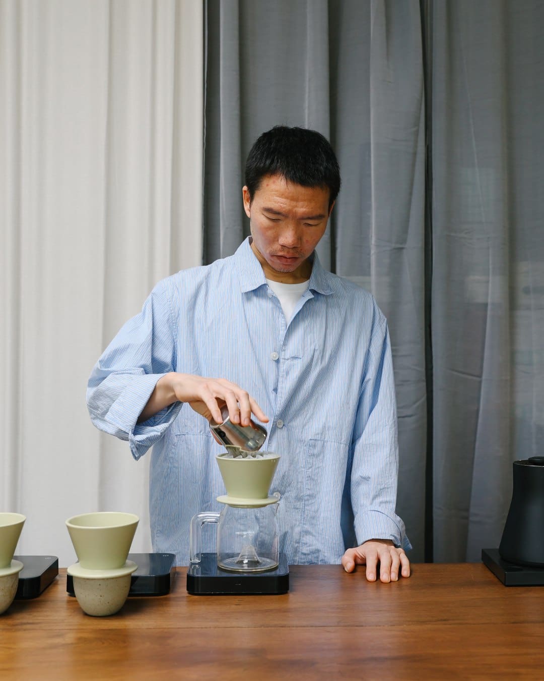 A. barista prepares a pour-over coffee at Hands and Heart in Bangkok