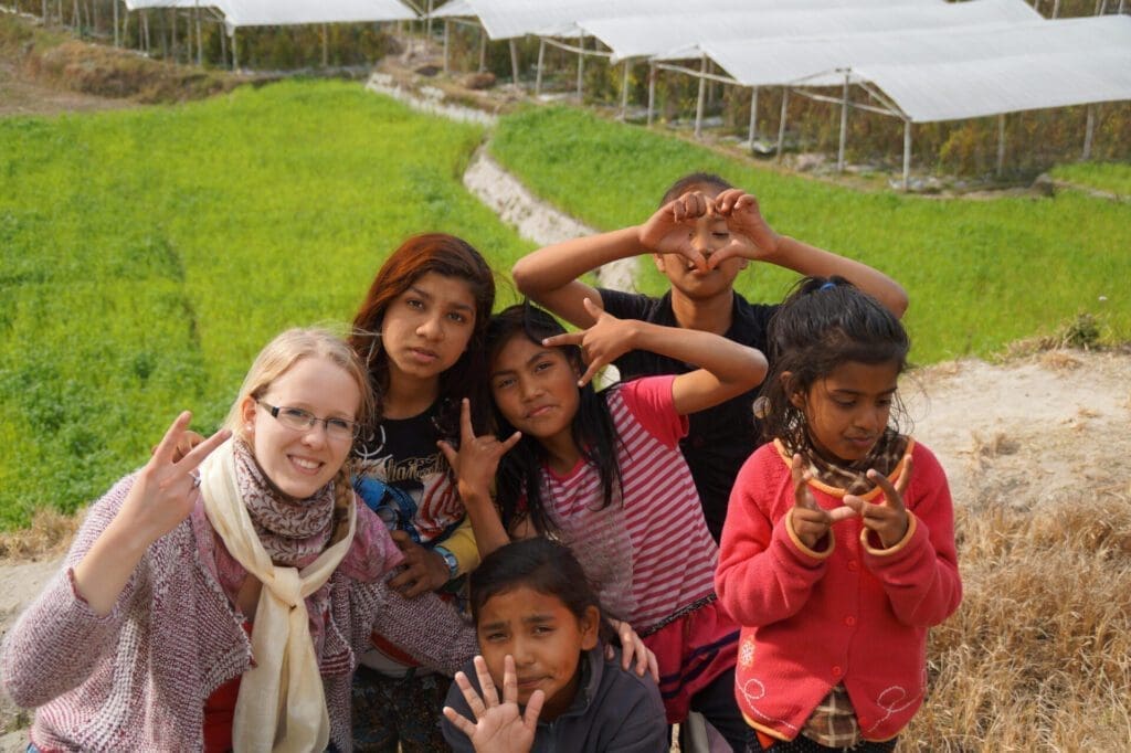 The negative effects of voluntourism: A European girl joking with children of an orphanage