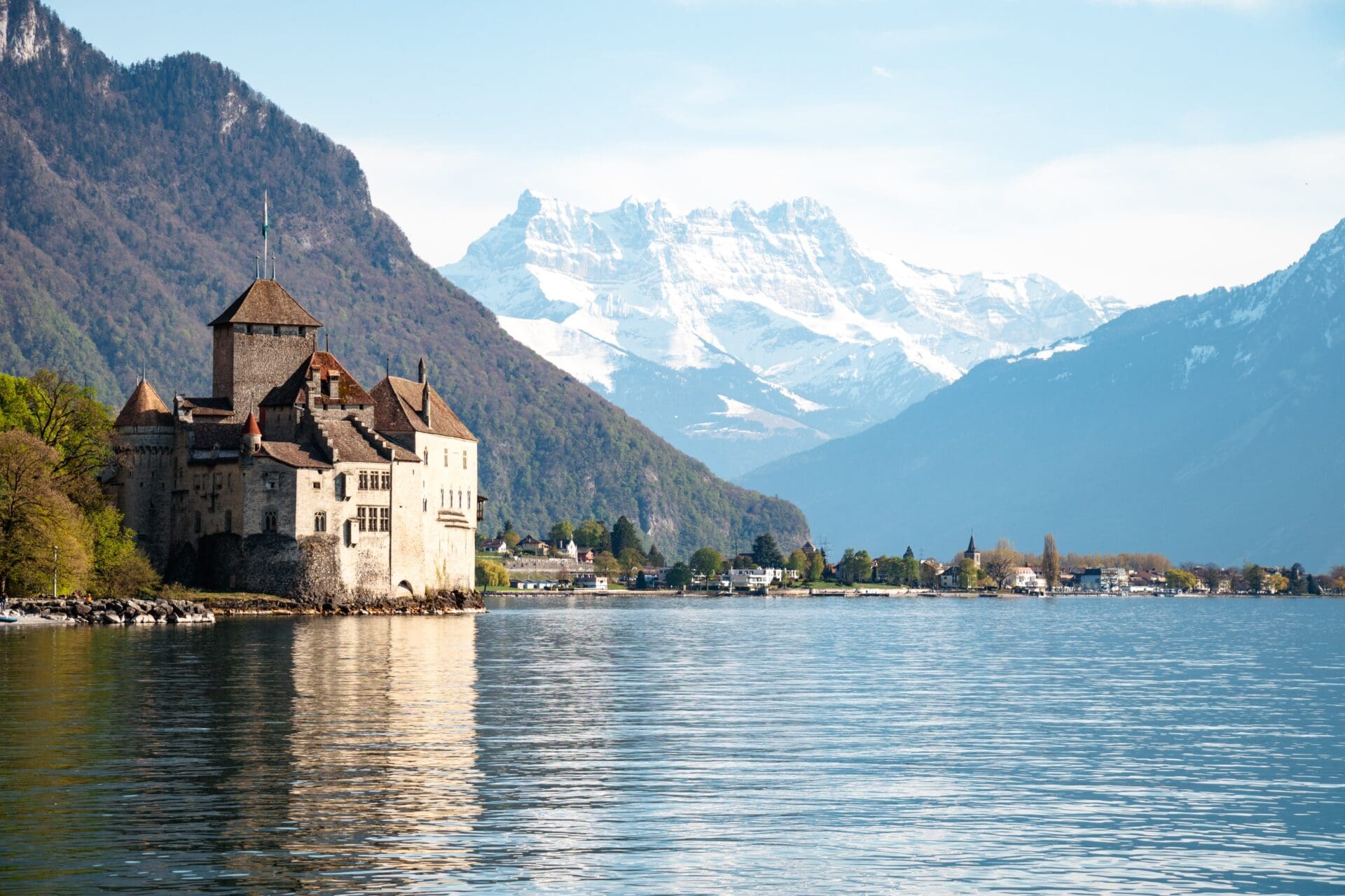 Train travel through Switzerland | Montreux castle against snowy mountains and Lake Geneva