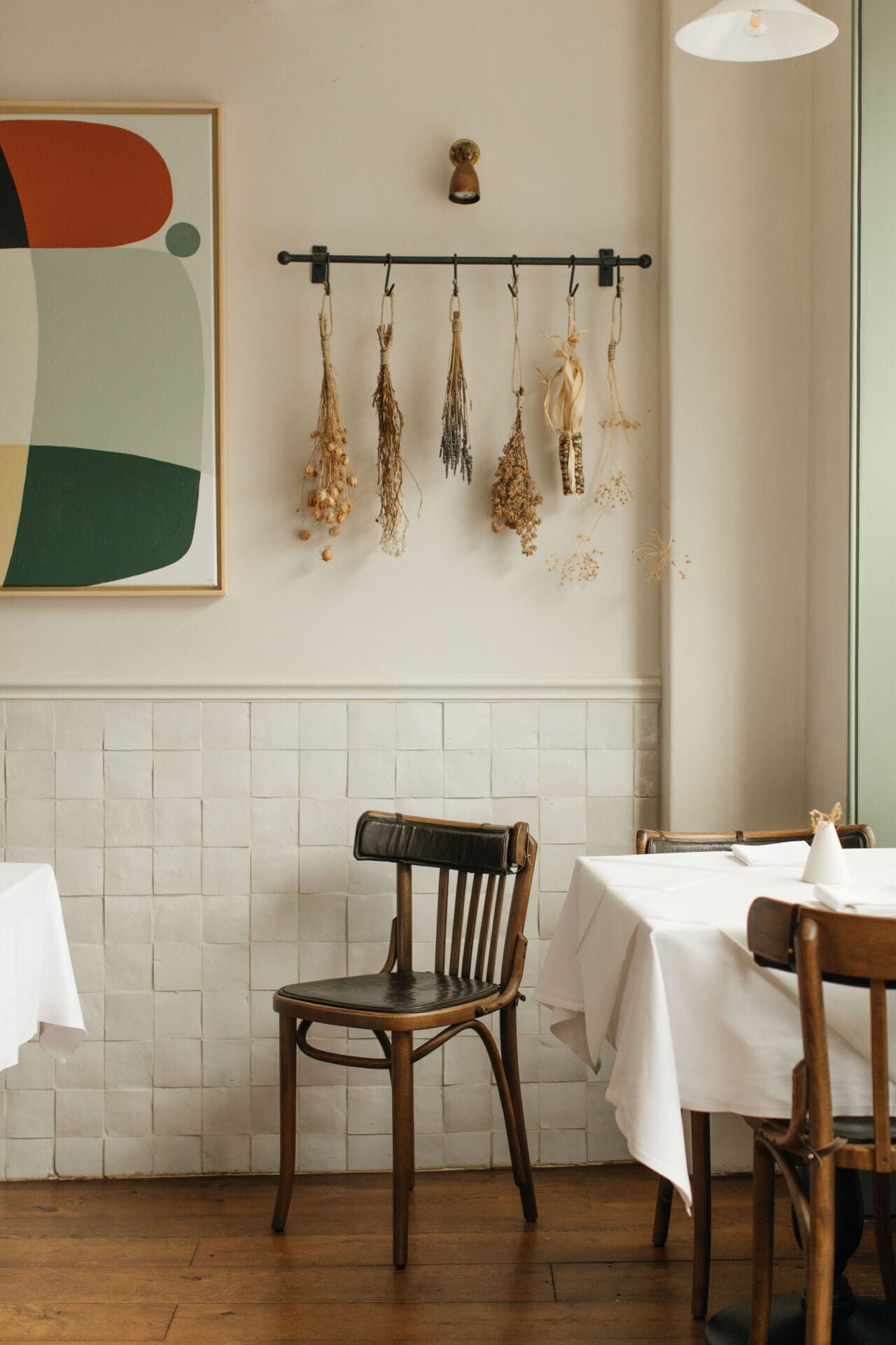 The best restaurants in Bruton | interiors as Osip, a wooden chair against a white tiled wall