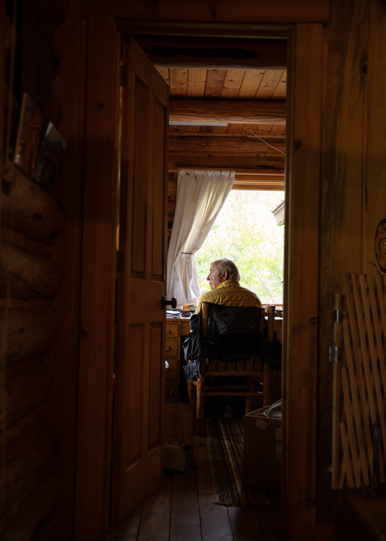 Patagonia founder Yvon Chouinard looks out of a window in a darkened room