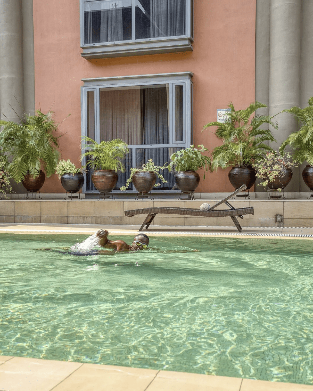 The best hotels in Lagos, Nigeria | The Wheatbaker, an outdoor swimming pool against a peach wall