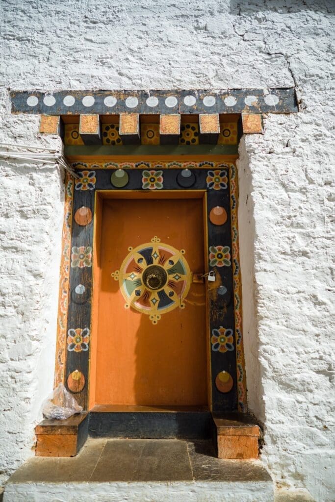 Bhutan reopens its borders | an orange door against a white stone wall 