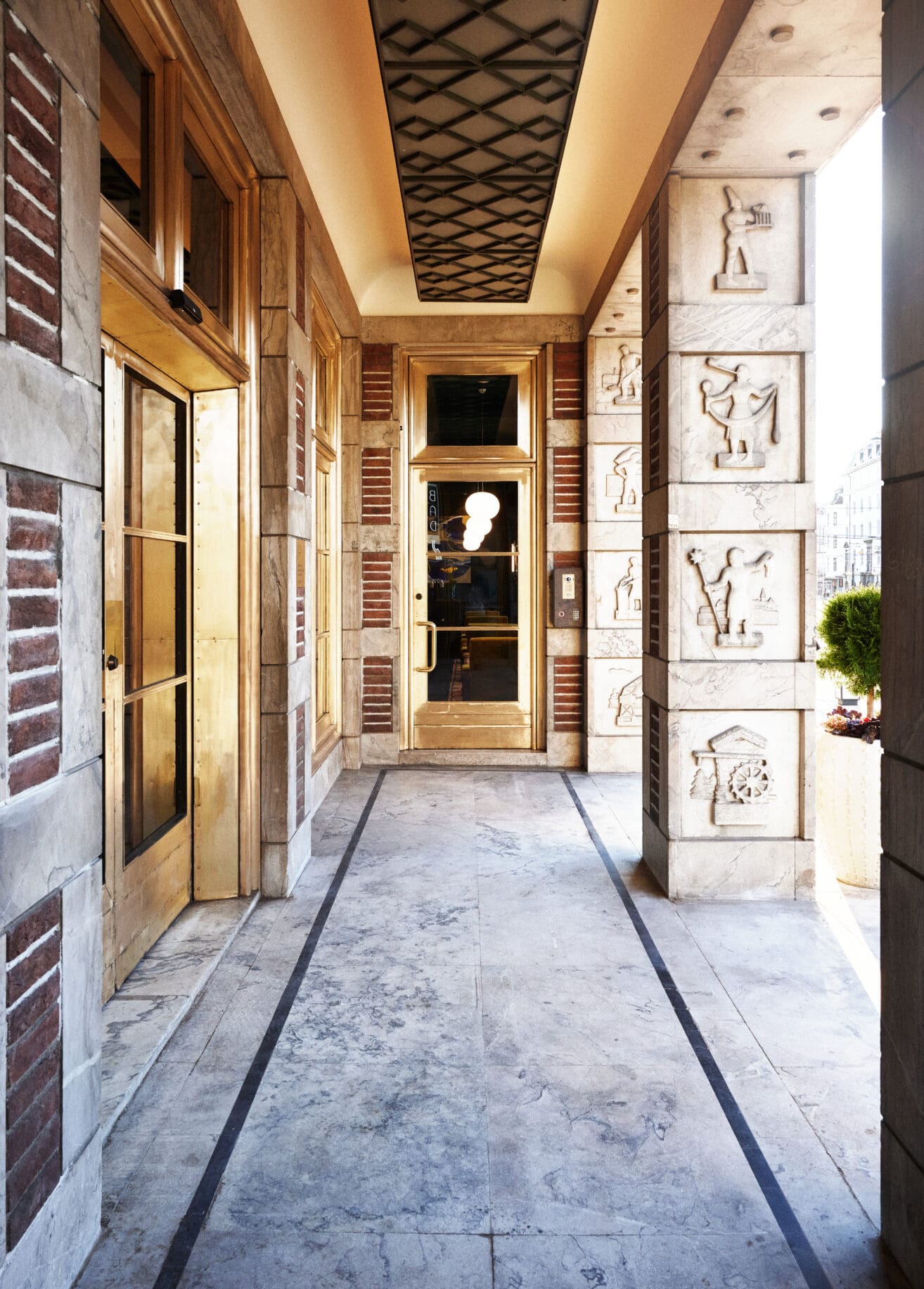 The entrance to Sommerro, a luxury hotel in Oslo | intricate stonework and an opulent gilded door