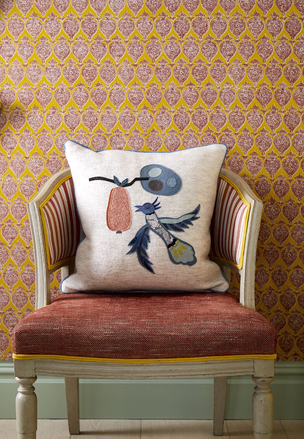 Kit Kemp interiors | A cushion appliquéd with a bird against a graphic orange wall