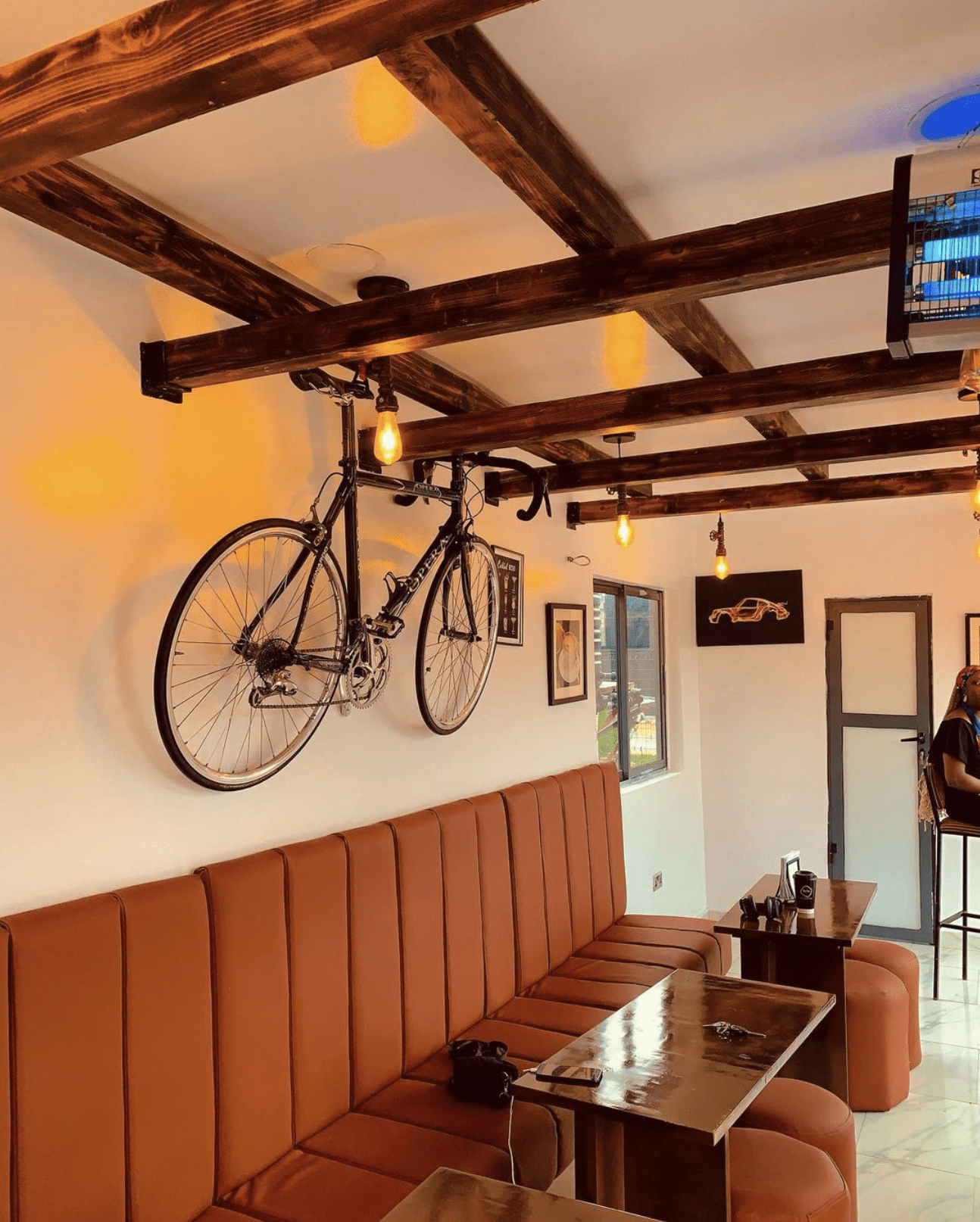 The best cafes in Lagos for remote workers | A retro road bike mounted to a wall above banquet seating and tabes at My Yas Cafe in Lagos