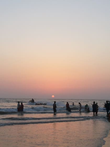 A weekend guide to Alibaug | Alibaug beach at sunset with a crowd of people enjoying the surf