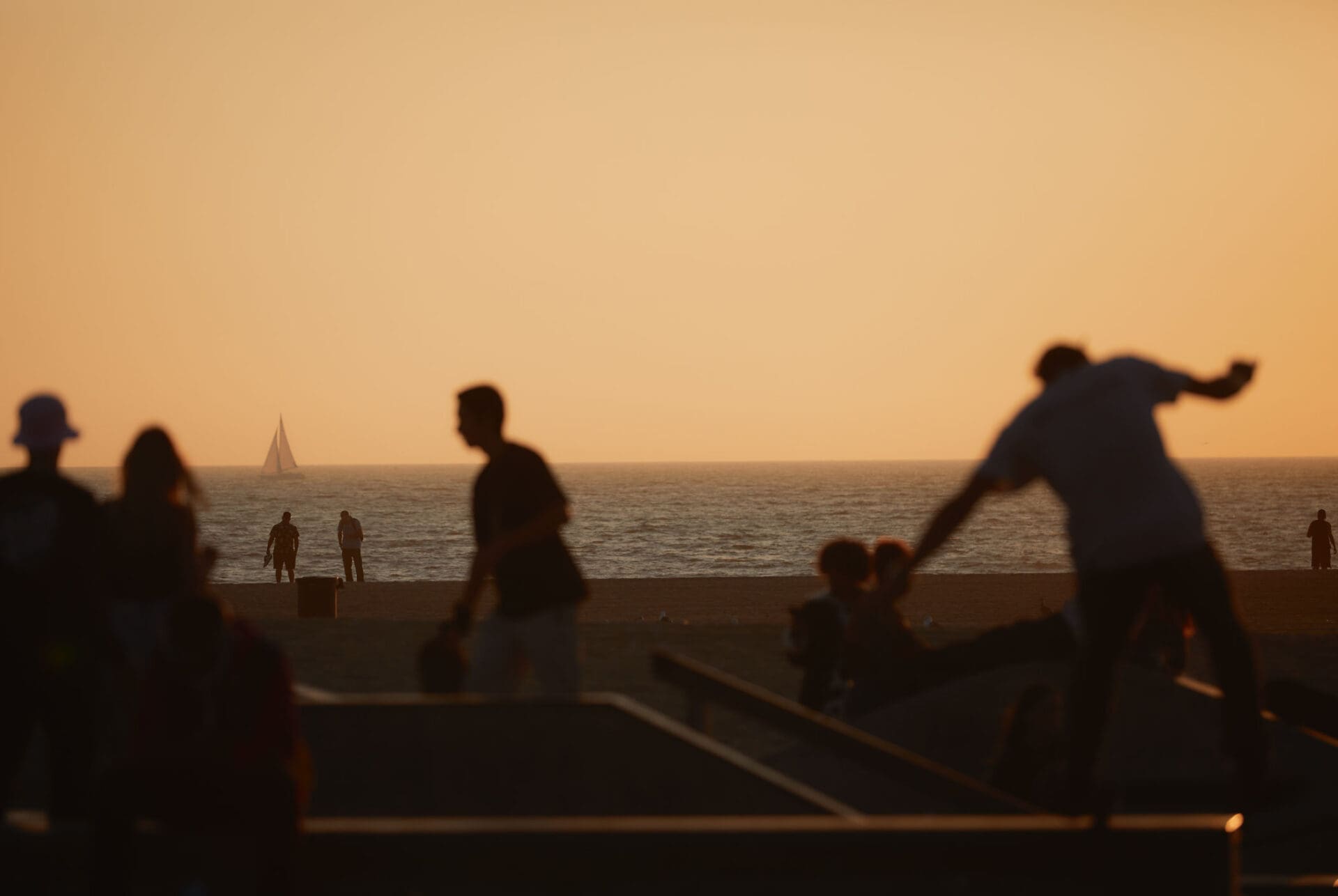 Focal Point, Erik Melvin | Skaters silhouetted against the ocean in a yellow haze. Photo by Erik Melvin