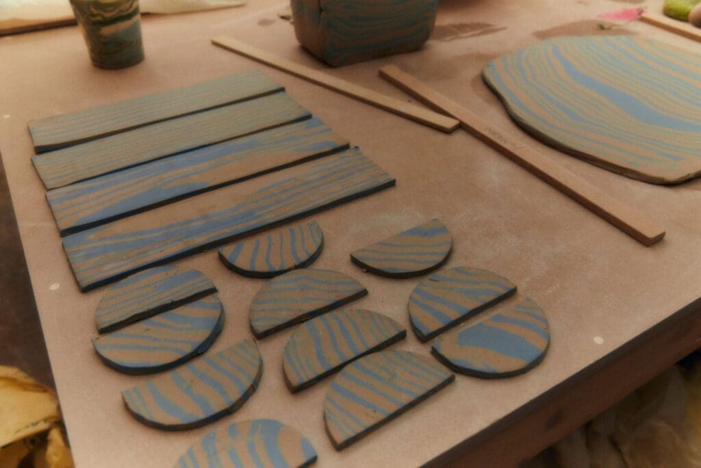 In the studio with Henry Holland | Handles and strips of clay cut on a workbench ready for firing.