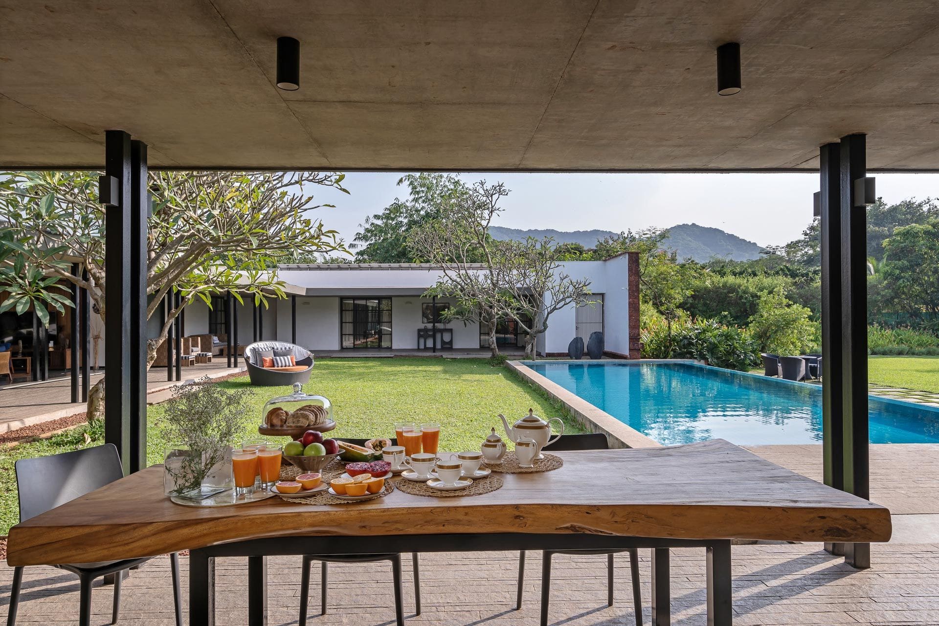 A weekend guide to Alibaug | a terrace dining table overlooking an expansive villa with pool