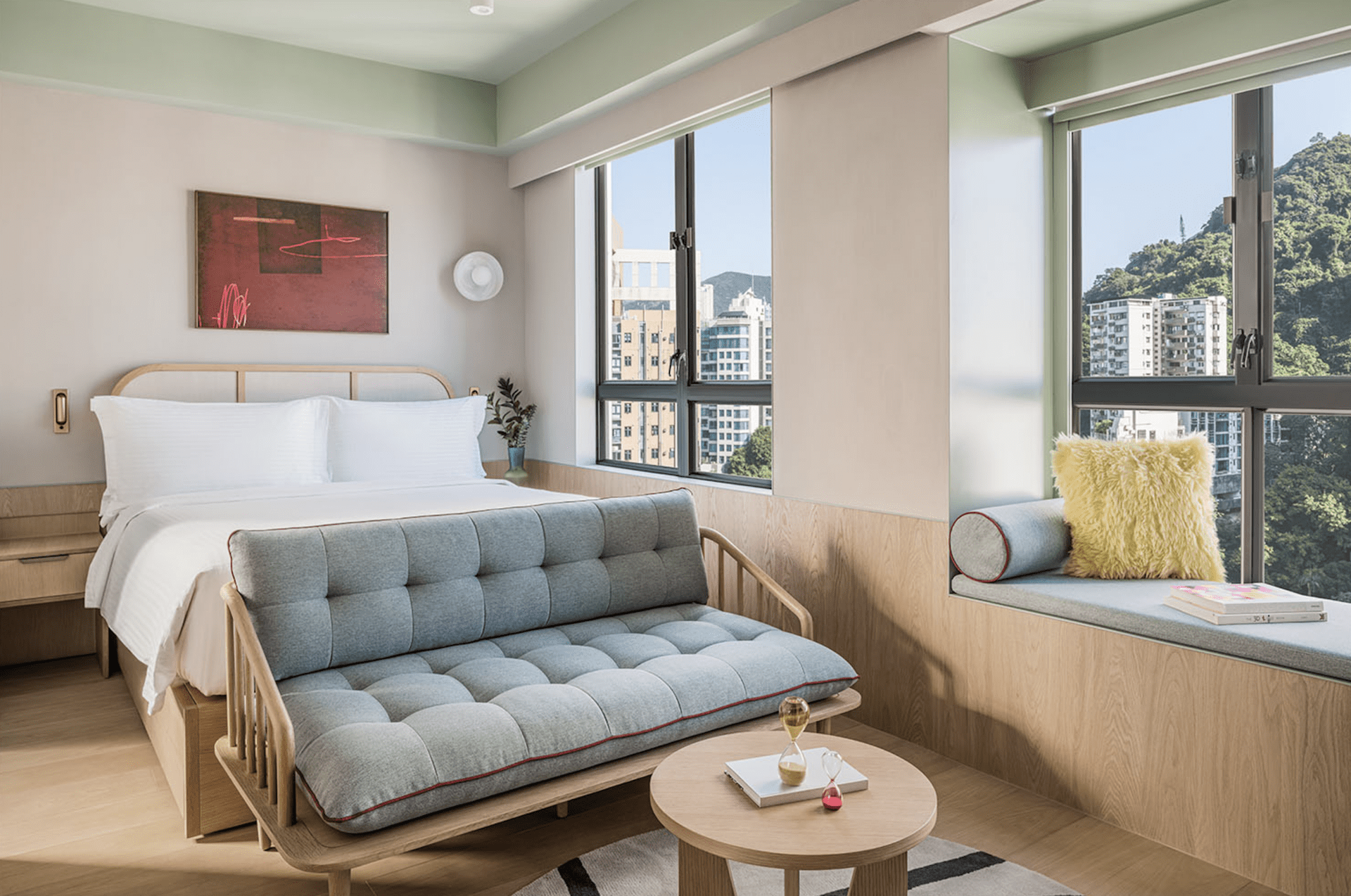 The Ying’nFlo hotel opens in Hong Kong | A minimalist room with a bed and sofa, and views of Wan Chai