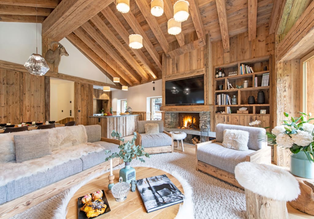 The most spectacular places to stay in the Alps this winter | A pine clad pitched roof sitting room with a fire