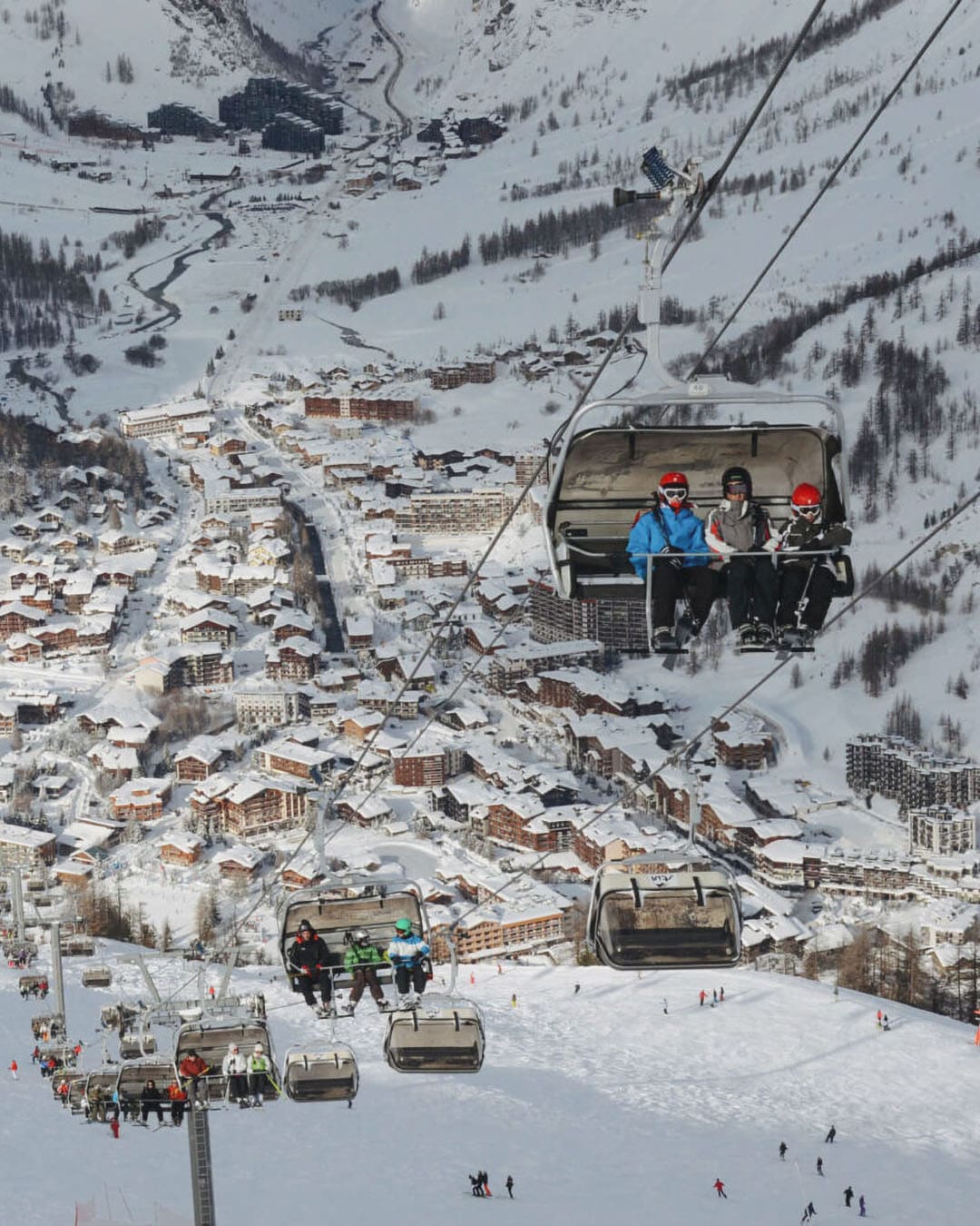 Skiers in a lift with Val D'Isere in background