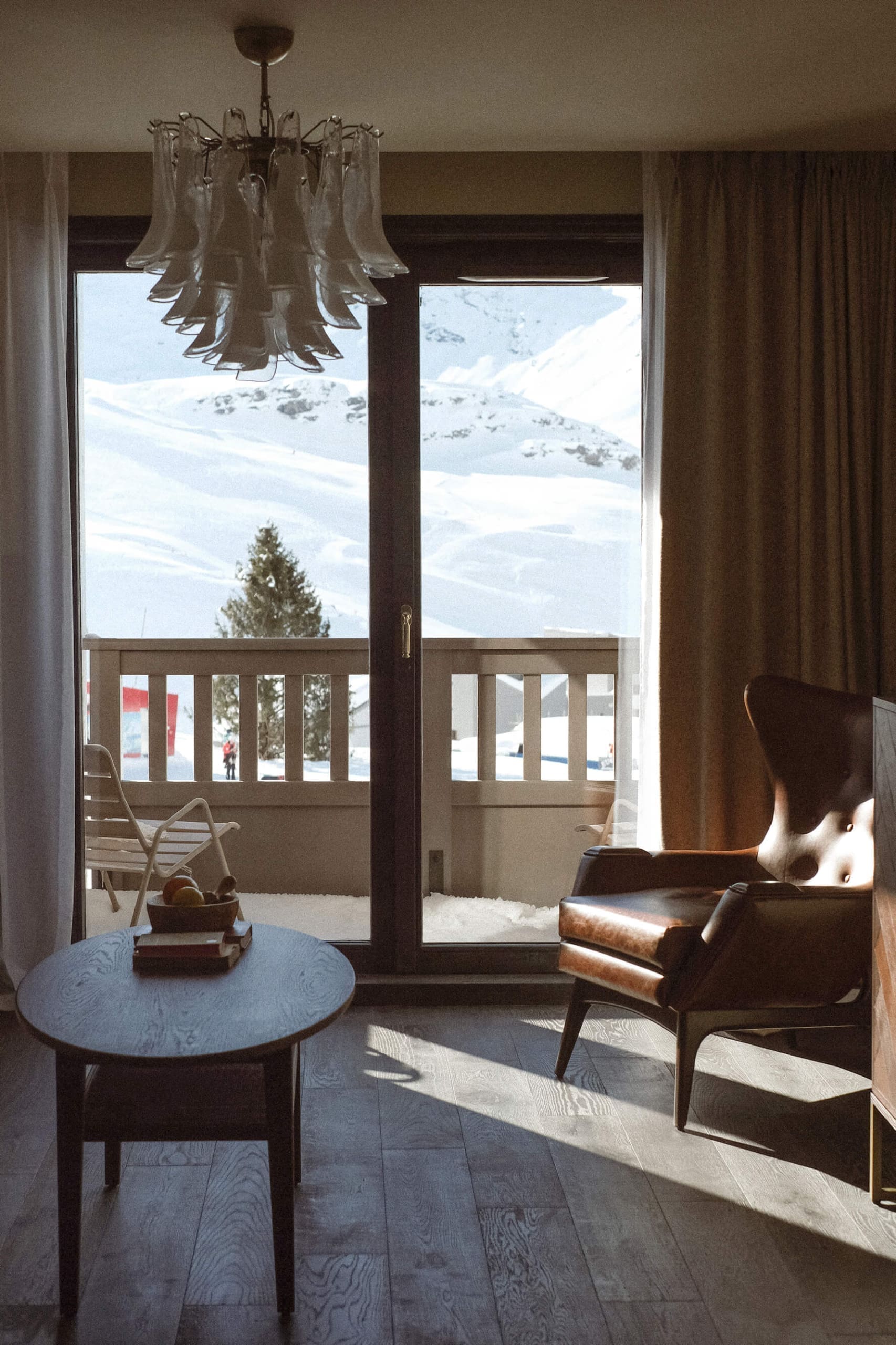 The most spectacular places to stay in the Alps this winter | An armchair against a private balcony in Le Fitz Roy, Val Thorens