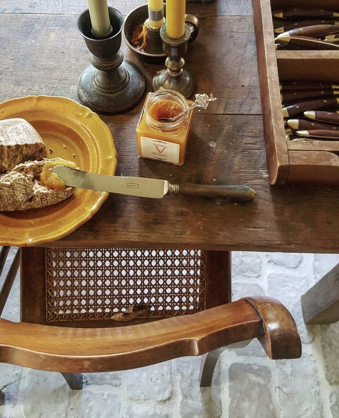 The best restaurants in Amsterdam | A dark wooden table with a knife spreading jam on bread.