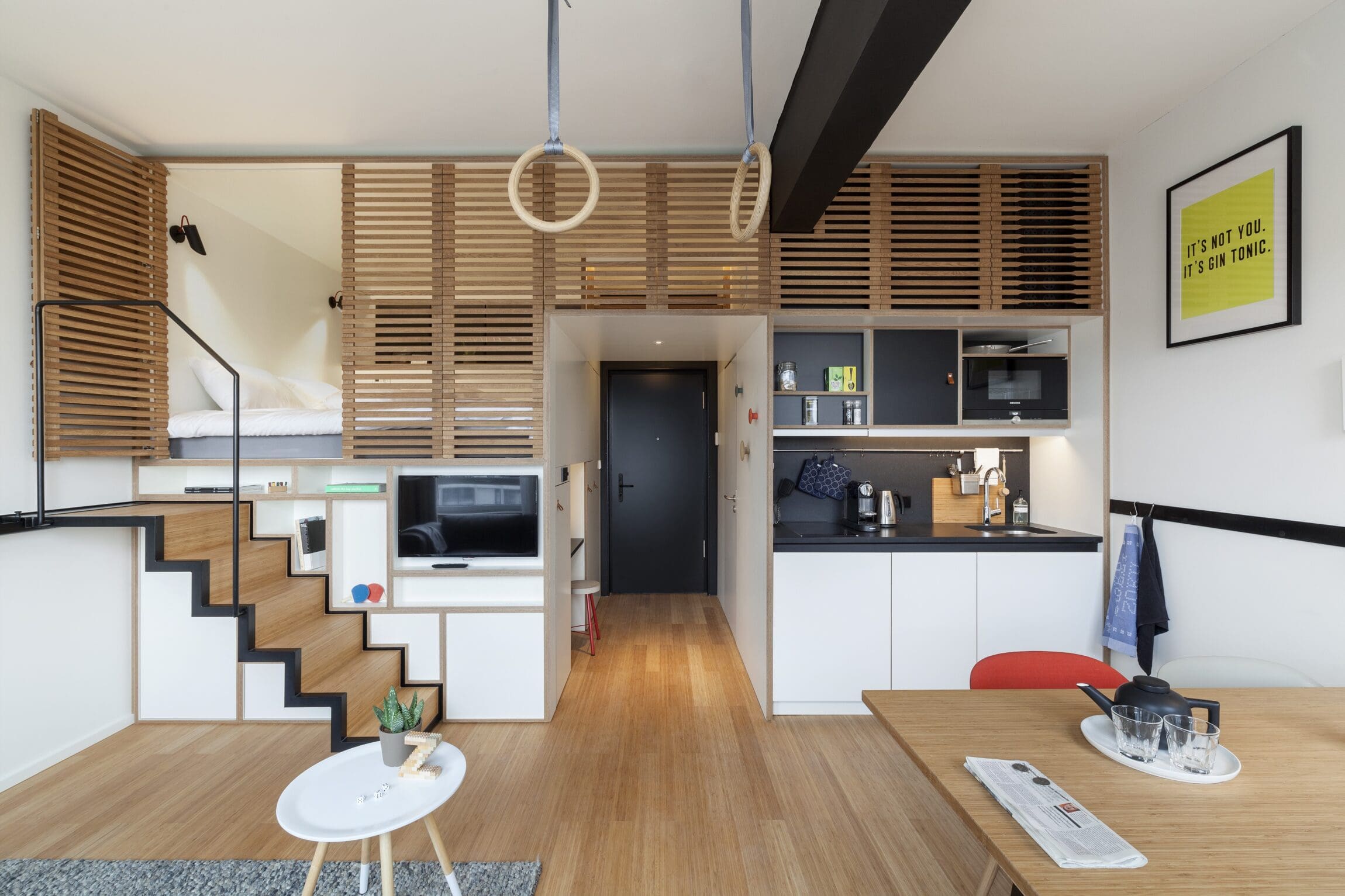 The best hotels in Amsterdam | This apartment style room at Zoku hotel features a lofted bed, a kitchen, and a dining table.
