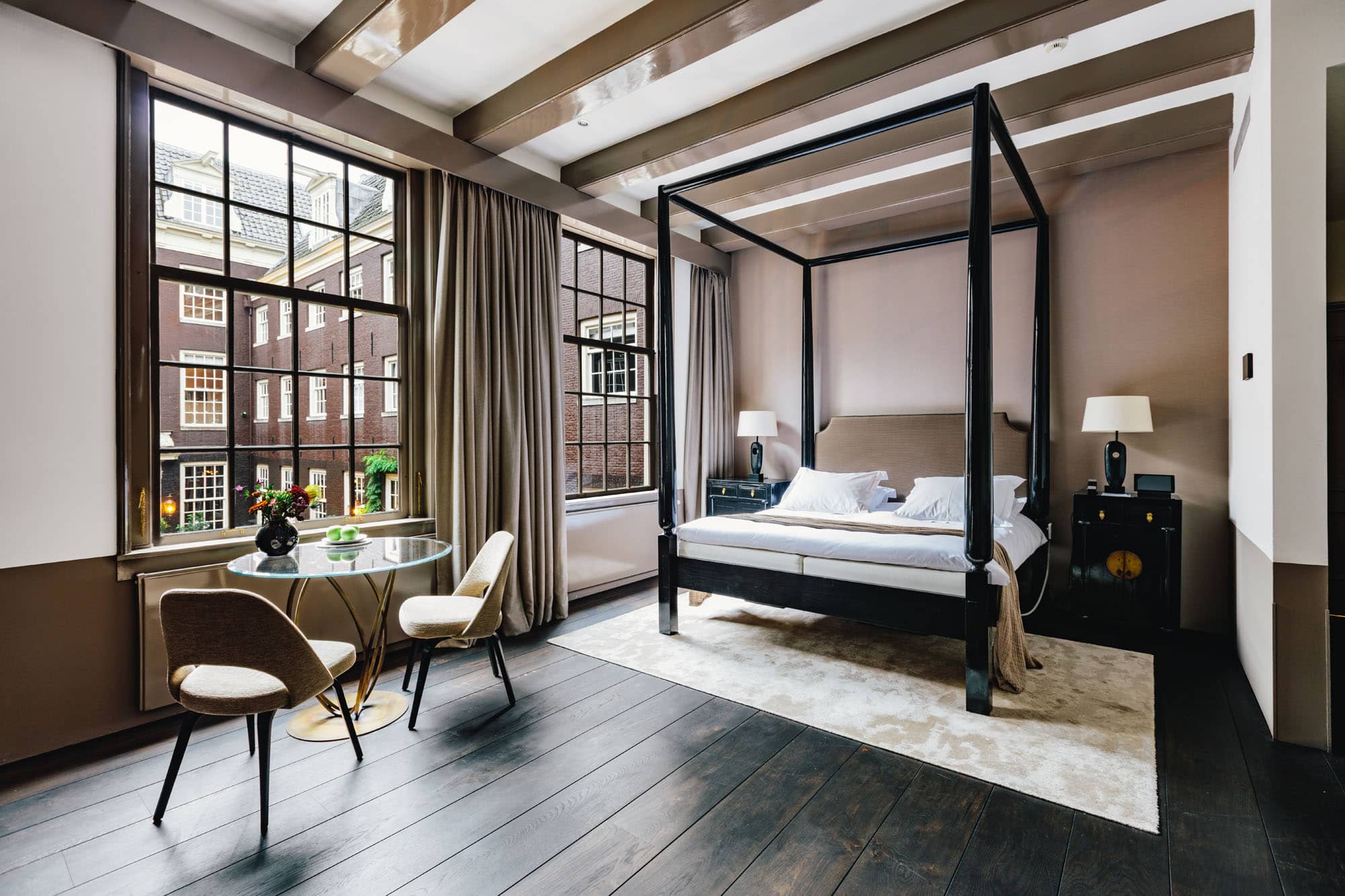 The best hotels in Amsterdam | Two large windows show natural light into the dark wood floors at the Dylan Hotel.