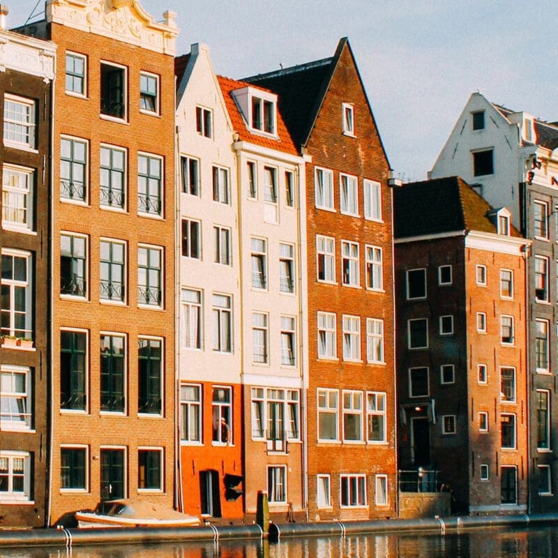 Amsterdam | Orange, brown, and white row houses along the canal.