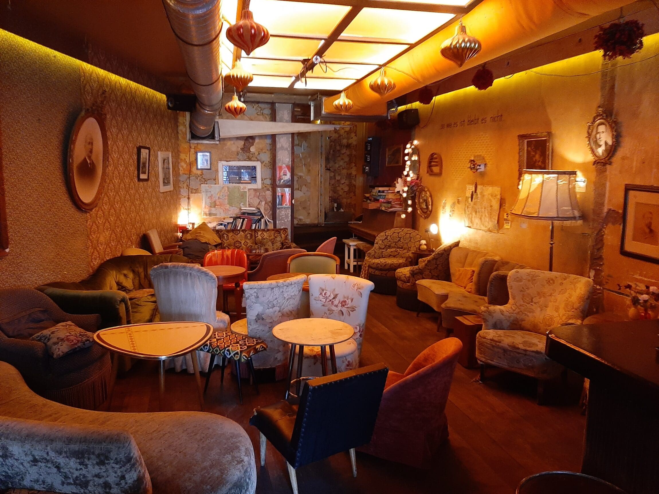 The best bars in Amsterdam | Cafe Brecht has various pattered chairs with a yellow and wallpaper background.