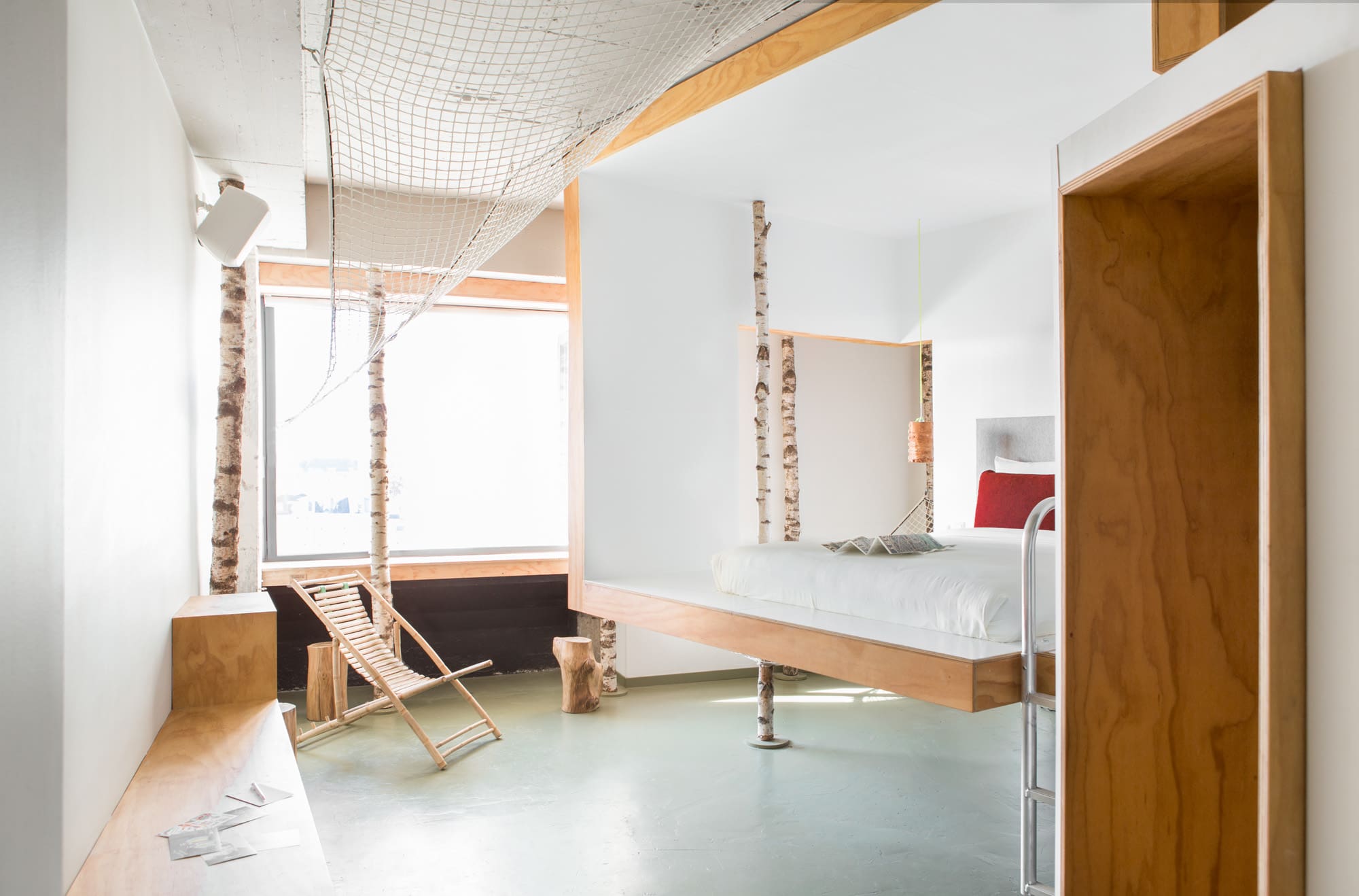 The best hotels in Amsterdam | Lofted bed in a light wood and white room at the Volkshotel.