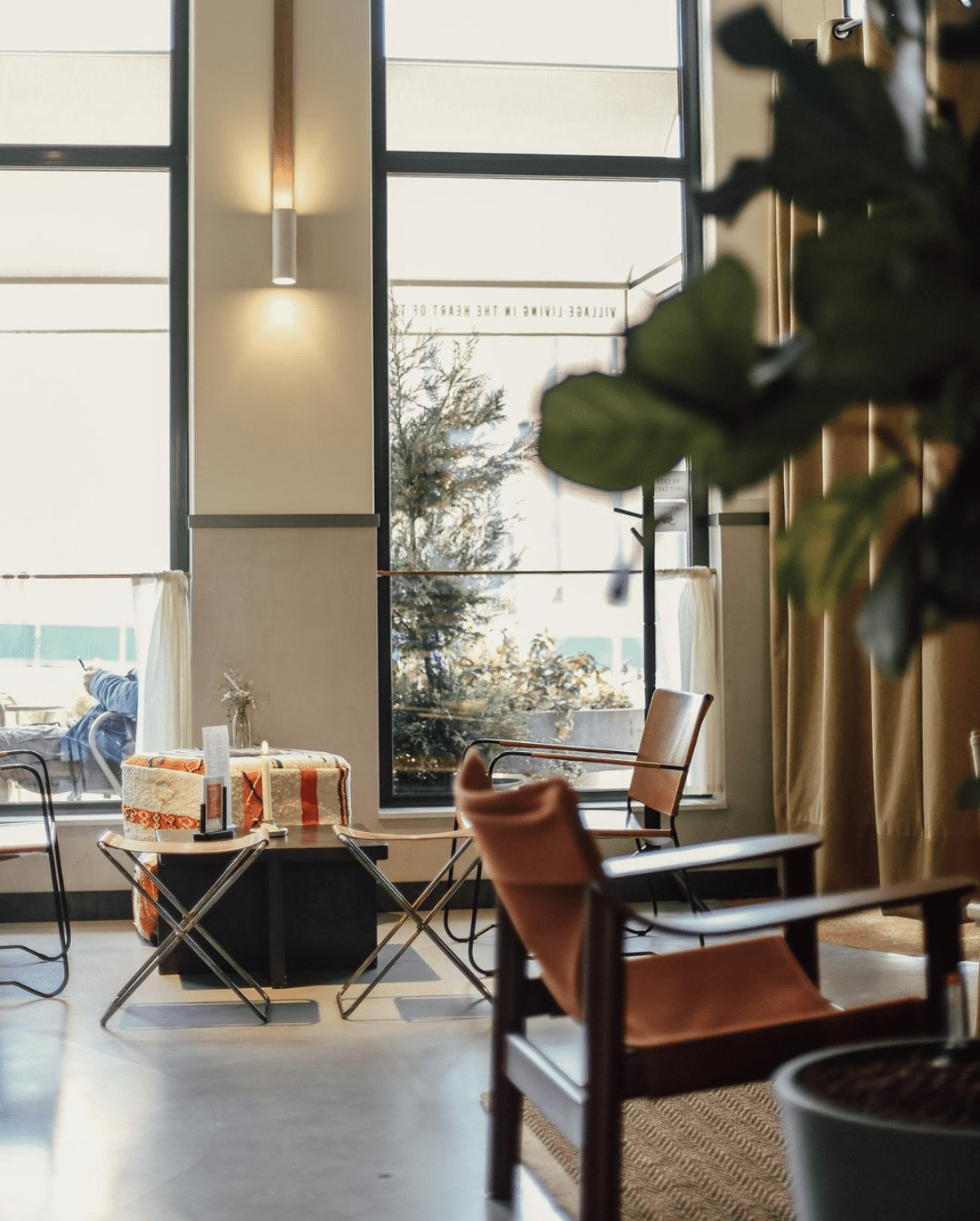 The best co-working spaces in Amsterdam | Chairs sit around tables next to floor to ceiling windows.