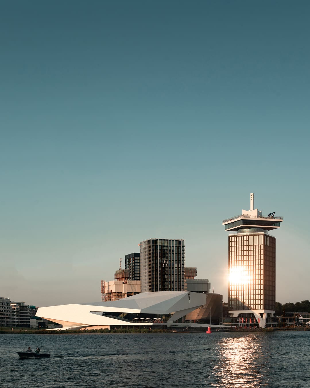 Amsterdam city guide | angular white facade of The Eye Filmmuseum in front of a blue sky by the waterfront in Amsterdam Noord