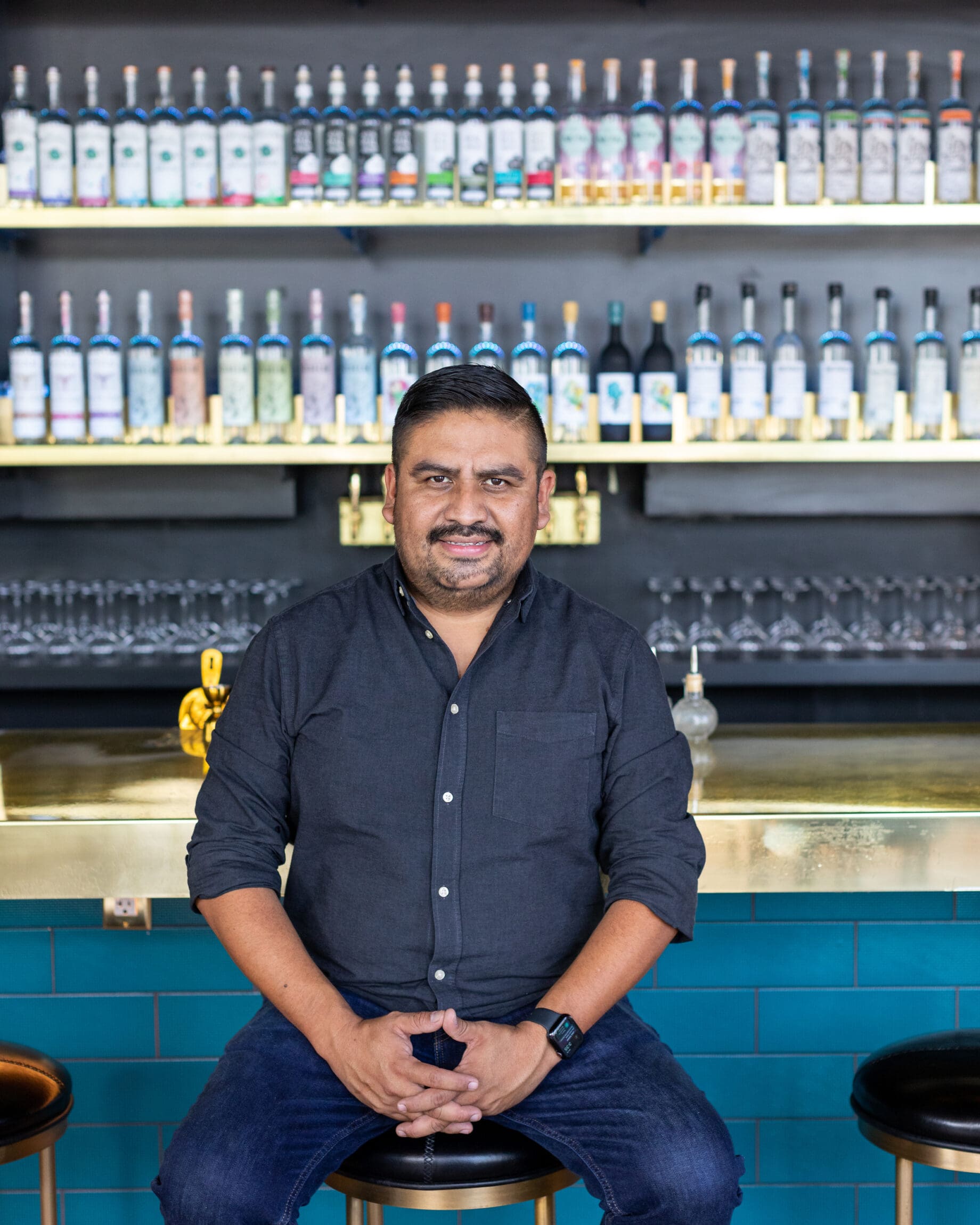 Ivan Vasquez sitting on a stool at Madre, his LA restaurant