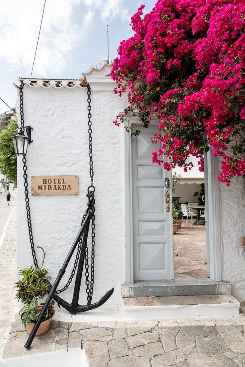 Bougainvilleau hangs over a rustic door at Hotel Miranda, Hydra