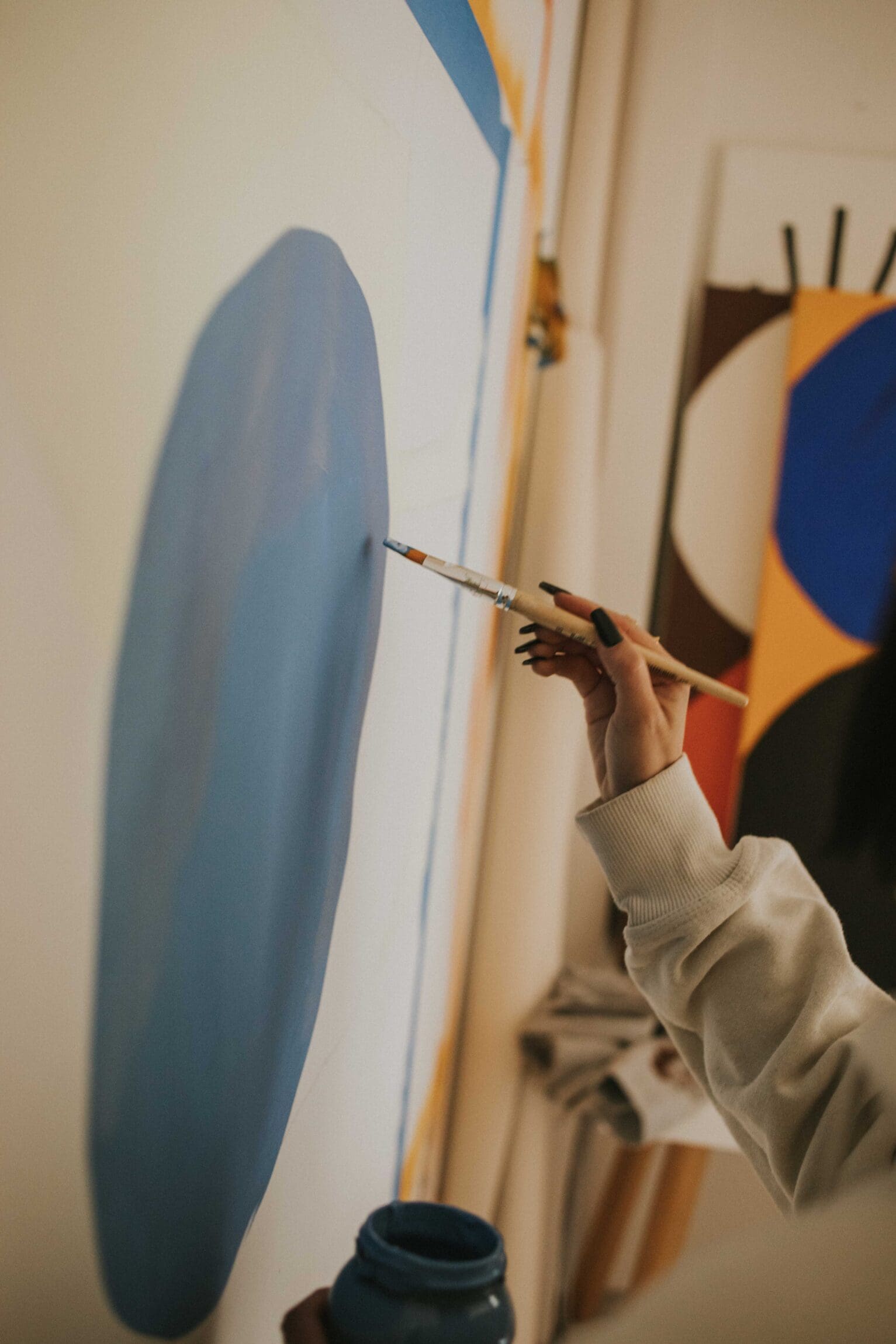 Artist Luisa Salas, aka Hola Lou, shot for ROADBOOK in her home studio, painting on canvas