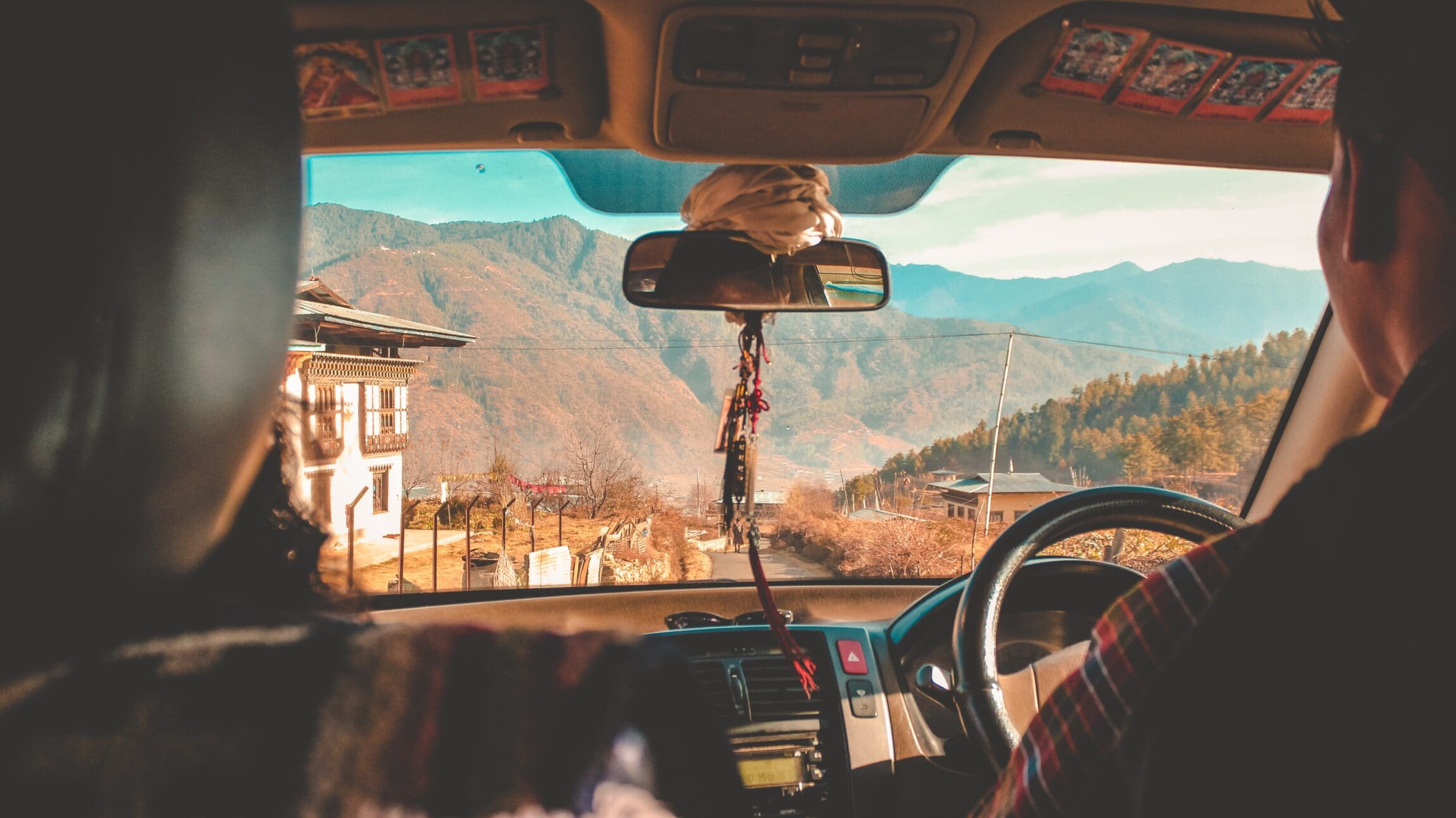 Tourist taxes | a person driving in Bhutan, with mountain views