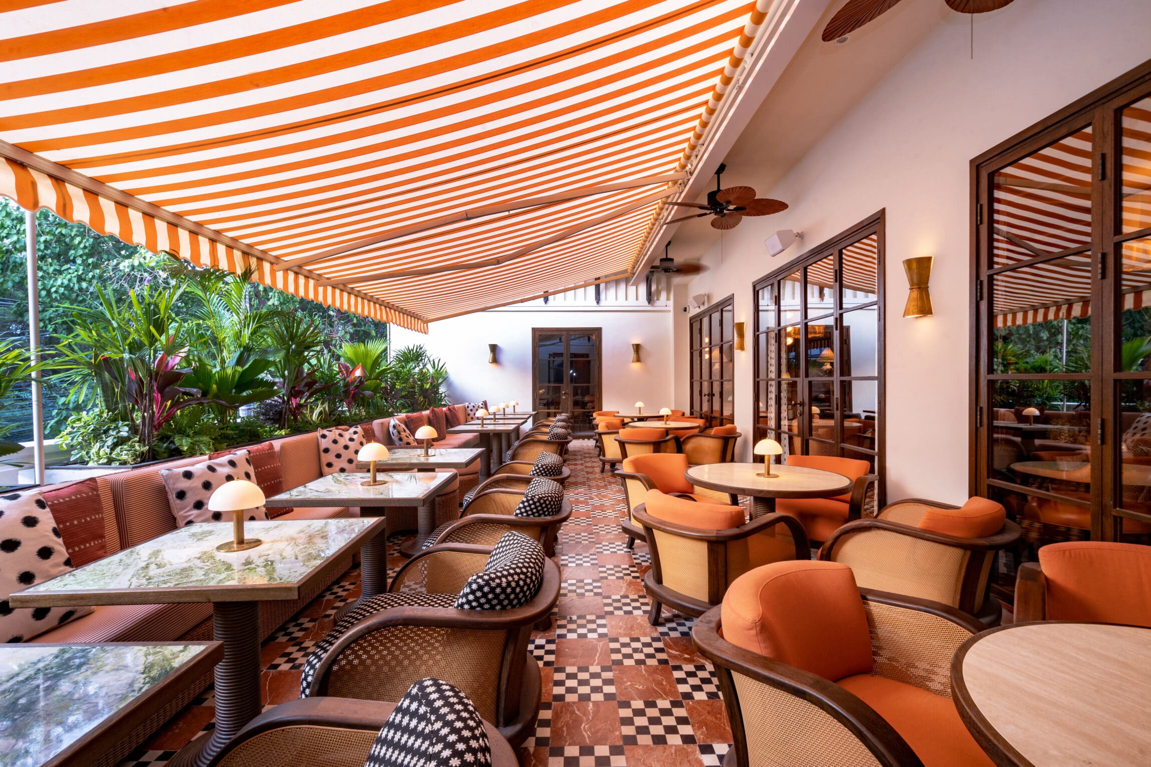 Soho House, Bangkok | the outdoor terrace with a striped awning overhead