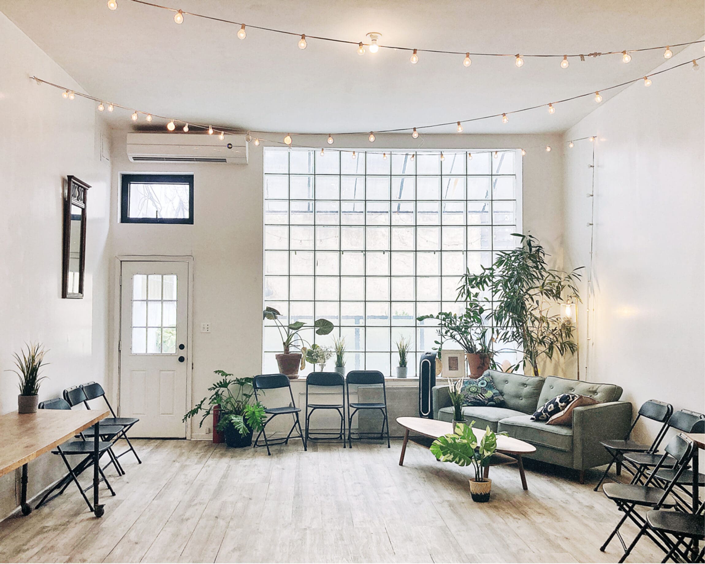 The best co-working space in New York | Couches, chairs, plants line the walls leaving the middle of the room empty.