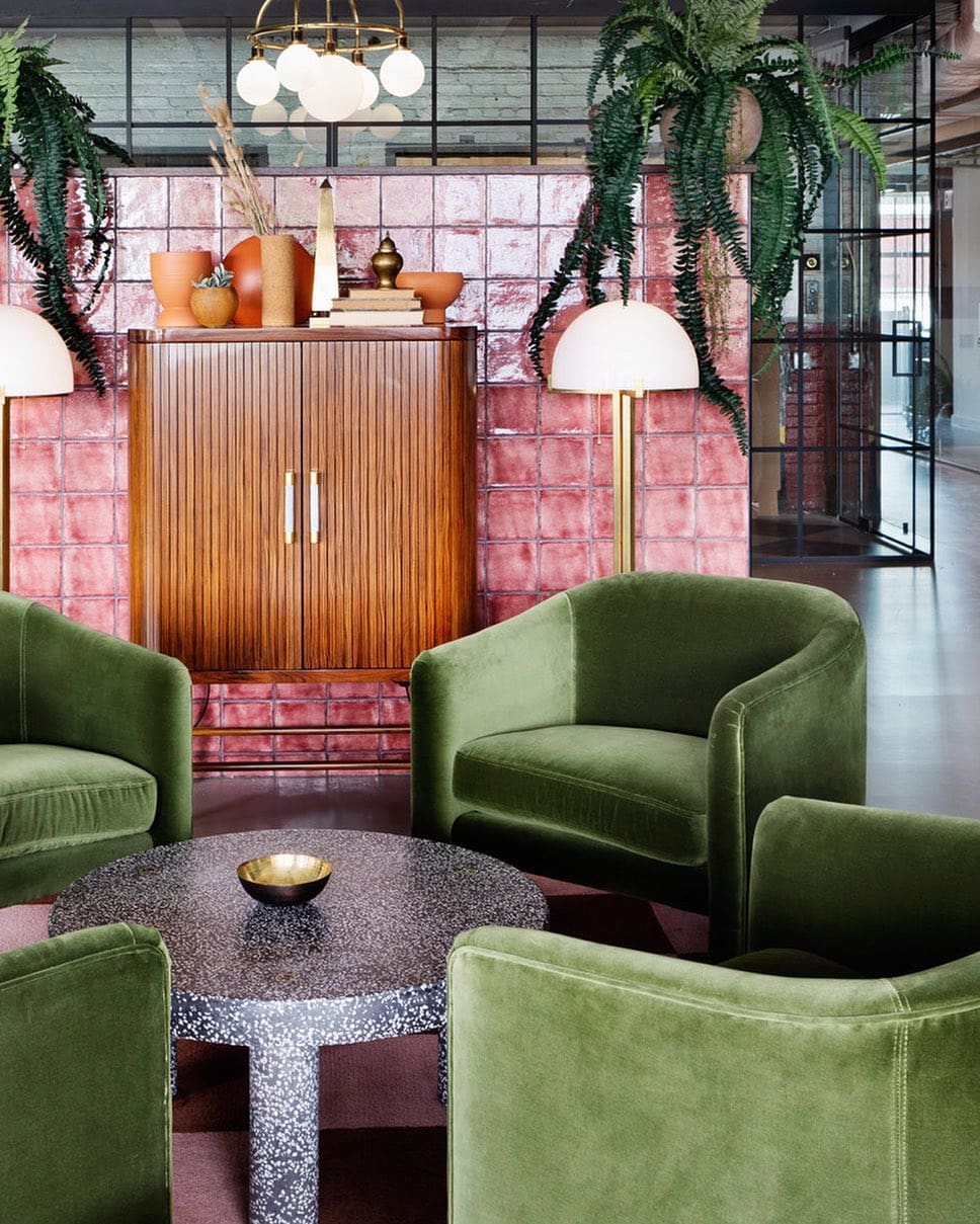 The best co-working spaces for remote working in New York City | Olive green velvet chairs and red tile inside the reception of Bond Collective