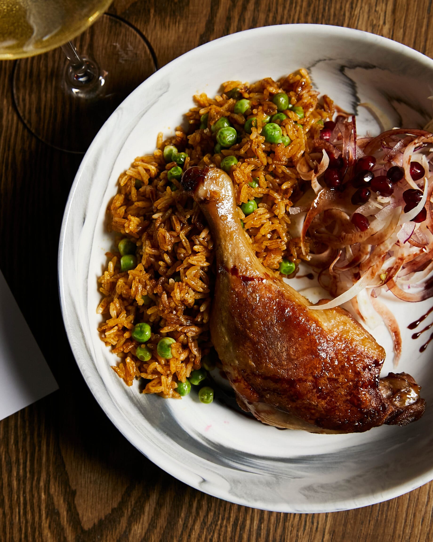 The best restaurants in New York City | Meat leg served with seasoned rice and pickled onion salad at Contendo
