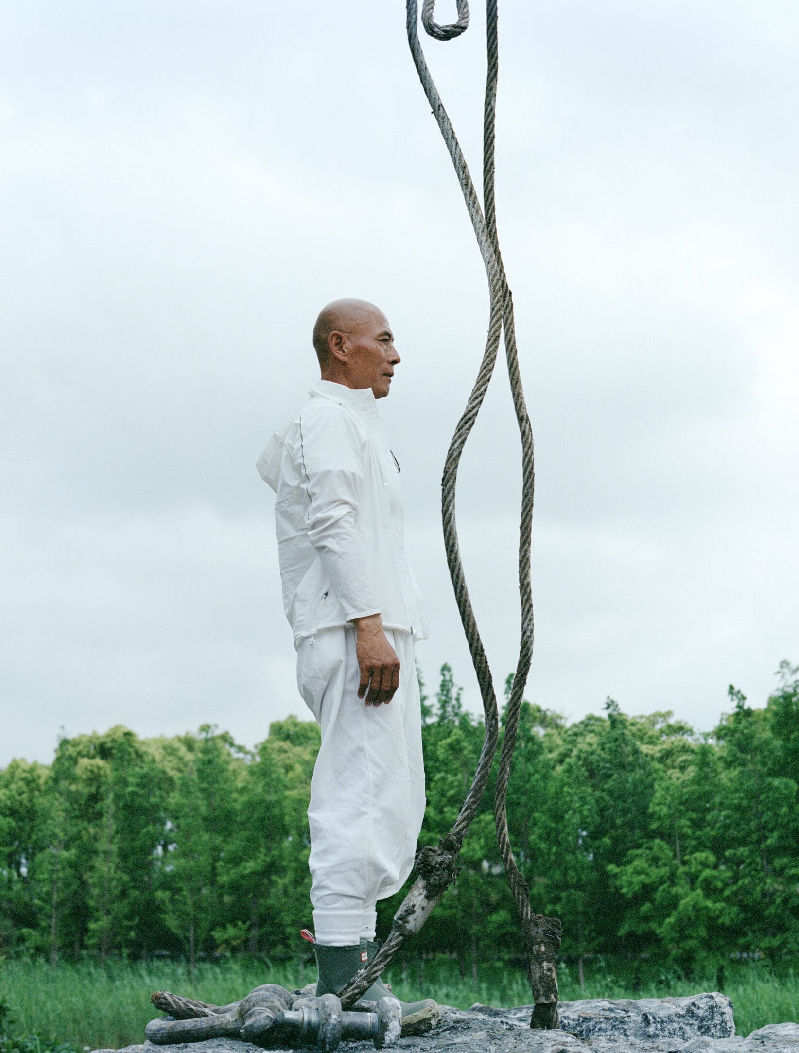 Chinese artist Zhang Huan standing in his Shanghai garden