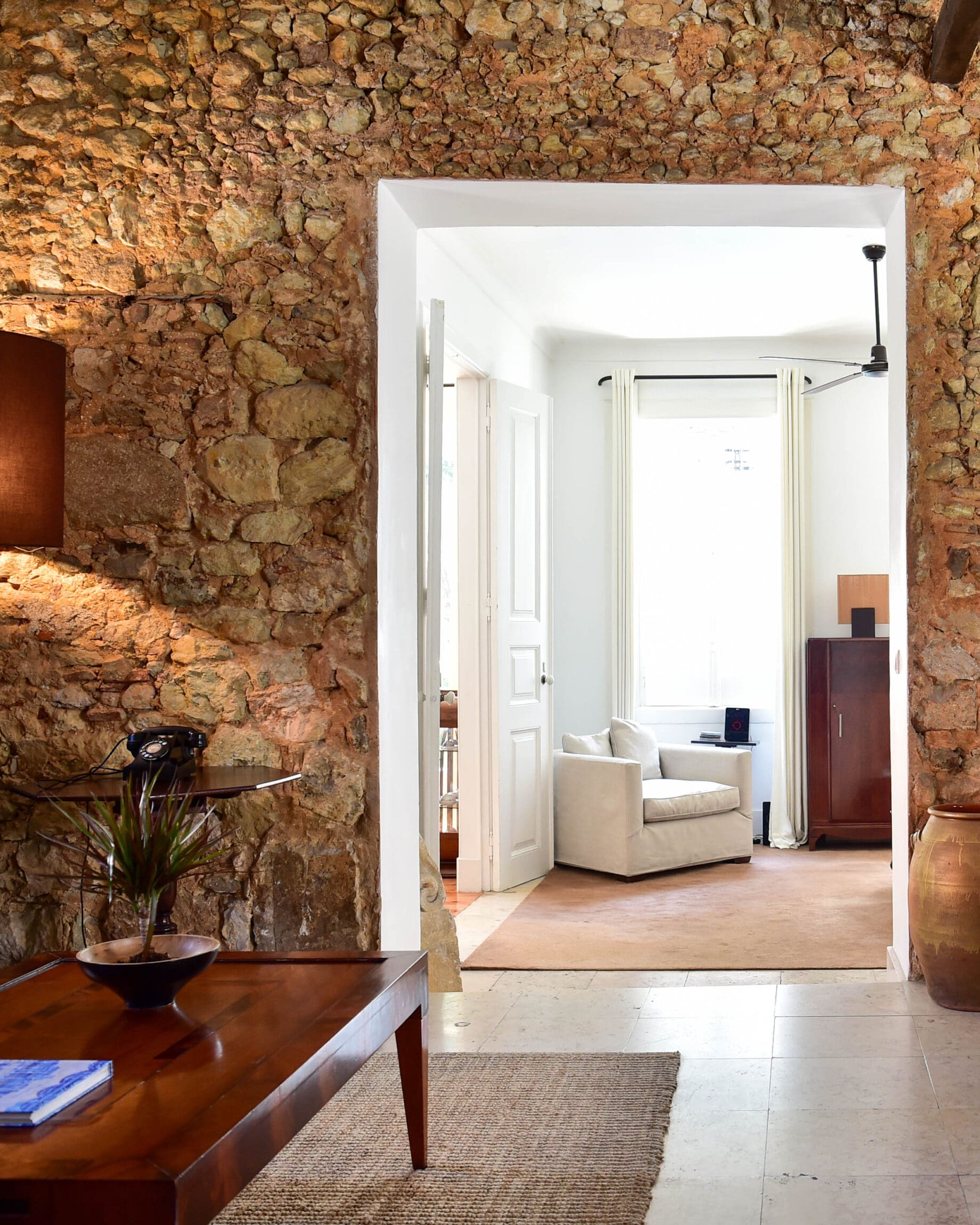 A stone archway leads to an airy hotel room at Casa Balthazar in Baixa