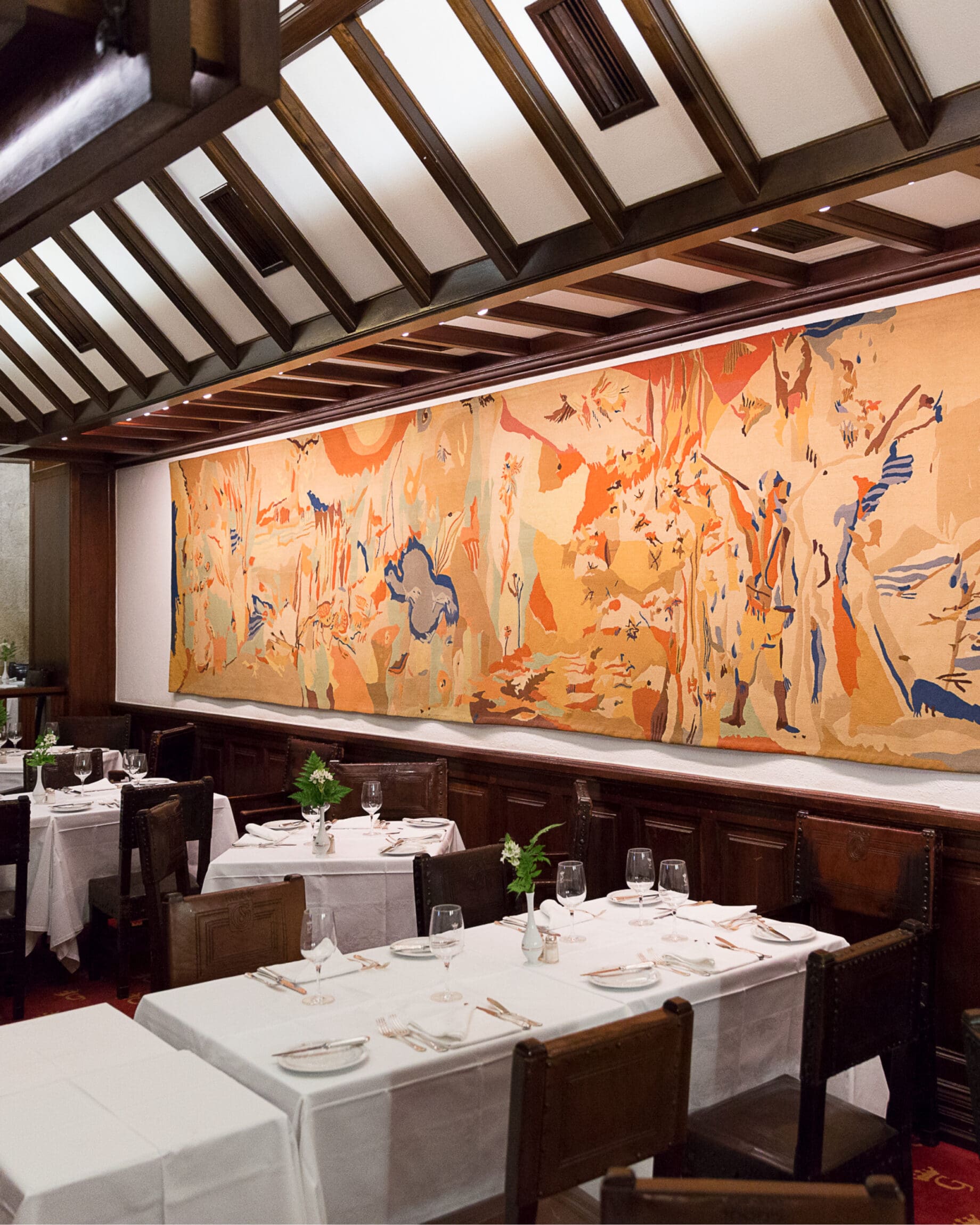 Dark wood, colourful murals and white tablecloths define the space at Gambrinus in Santa Maria Maior