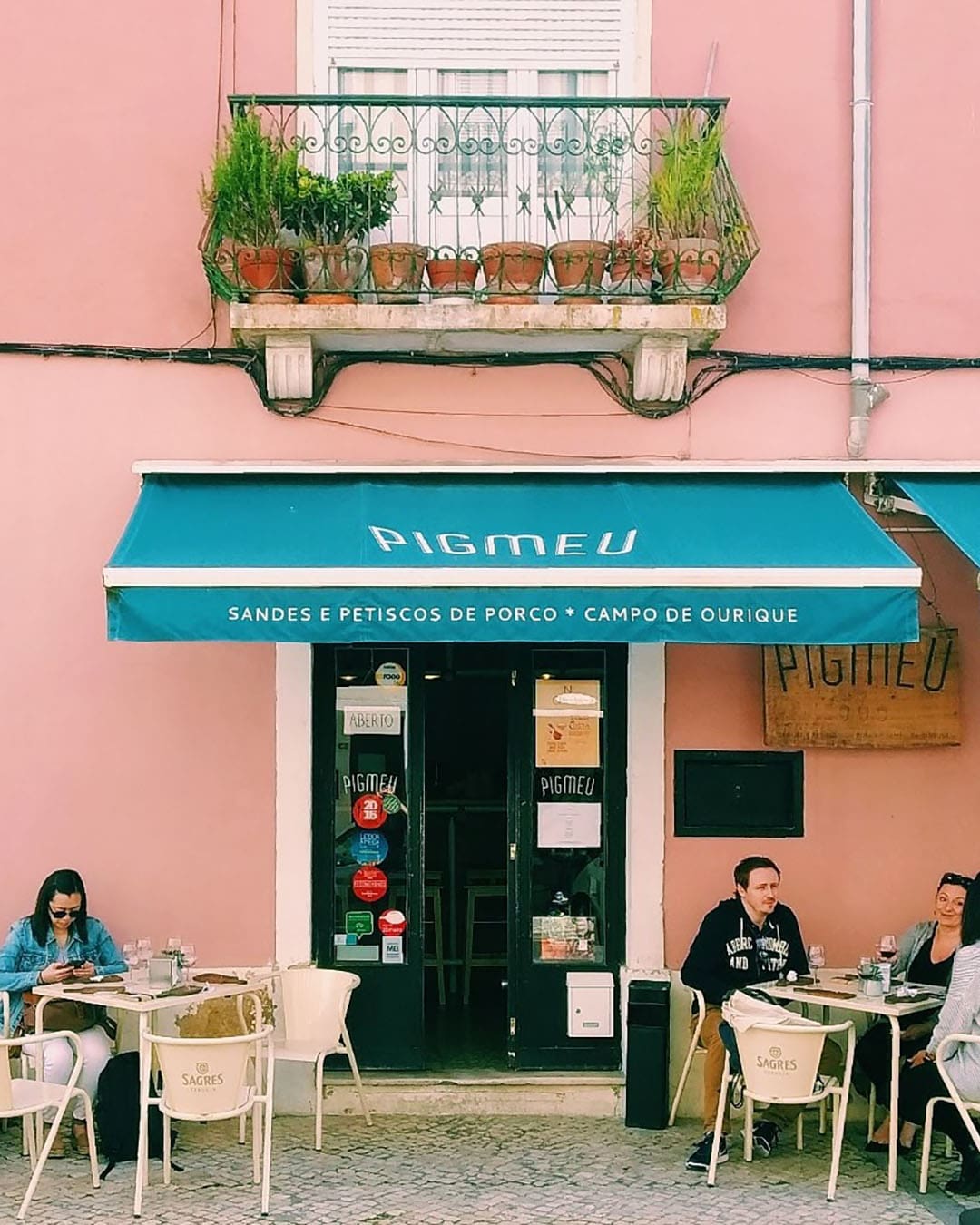 The pink exterior and outdoor seating at Pigmeu, Campo de Ourique