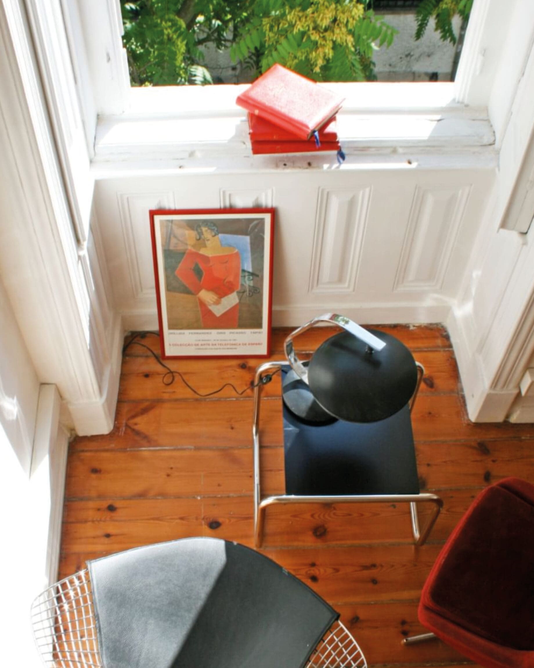 A cosy corner with abstract artwork and a window at Independente Principe Real Hostel and Hotel in Lisbon