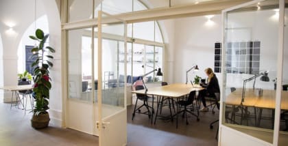 A light-filled co-working space in Lisbon with a desk in view