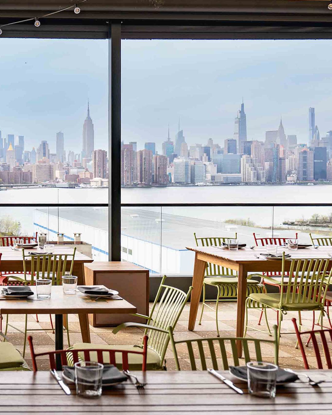 New York Skyline from Laser Wolf, showing a warm atmosphere. Very clean lines and tables and chairs.